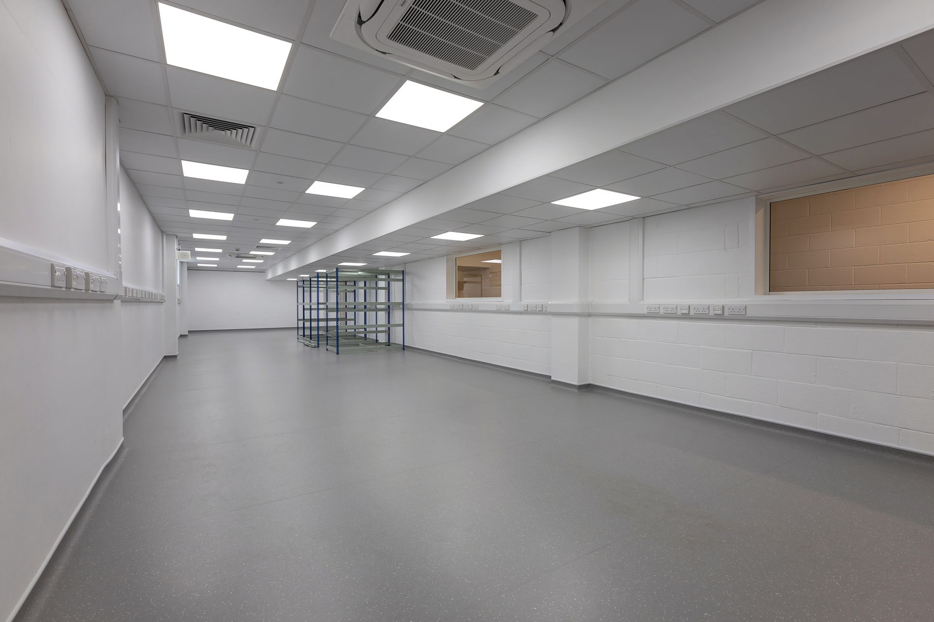 A large empty room with a gray floor and white walls.