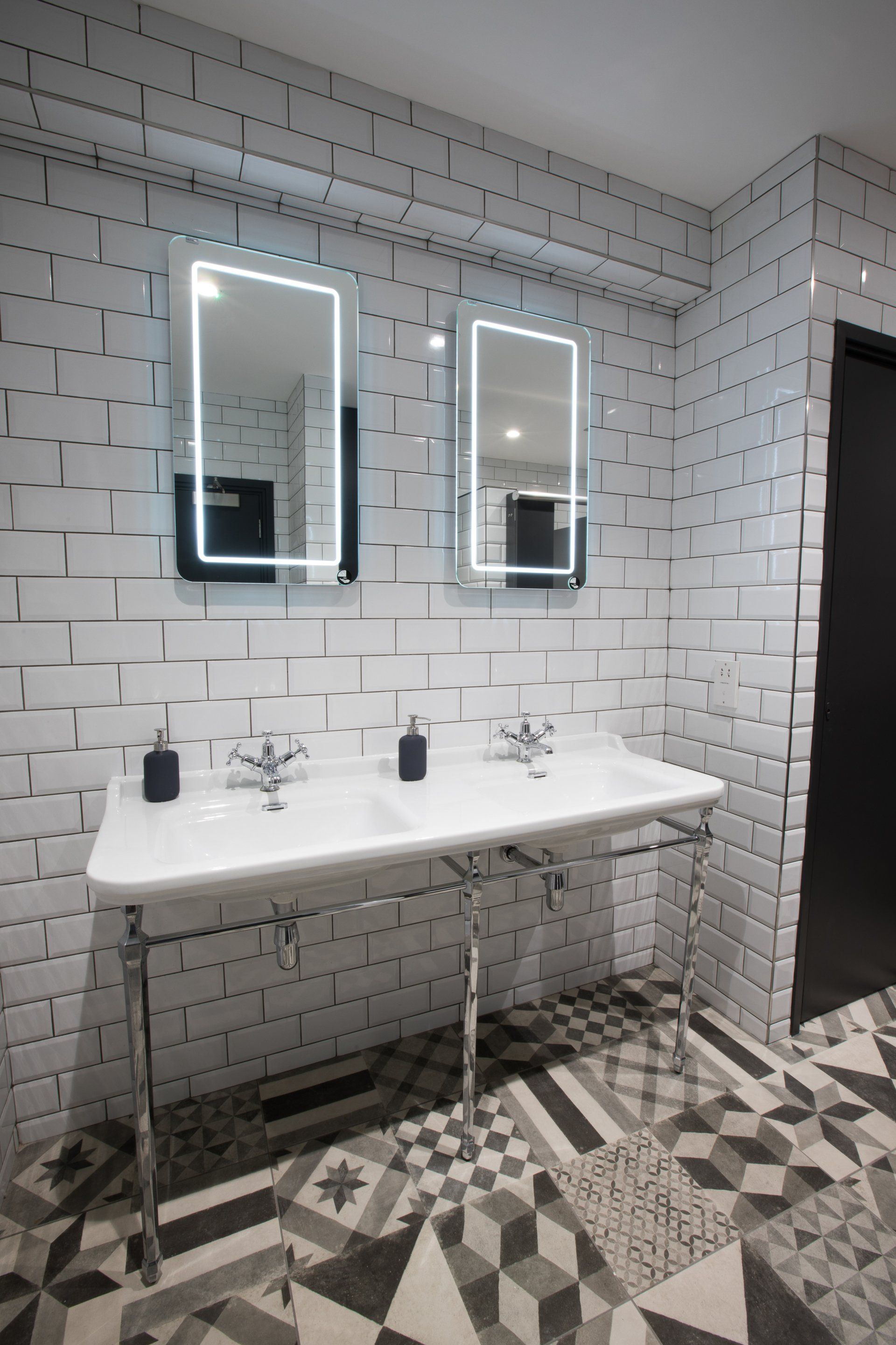 A bathroom with two sinks and two mirrors.