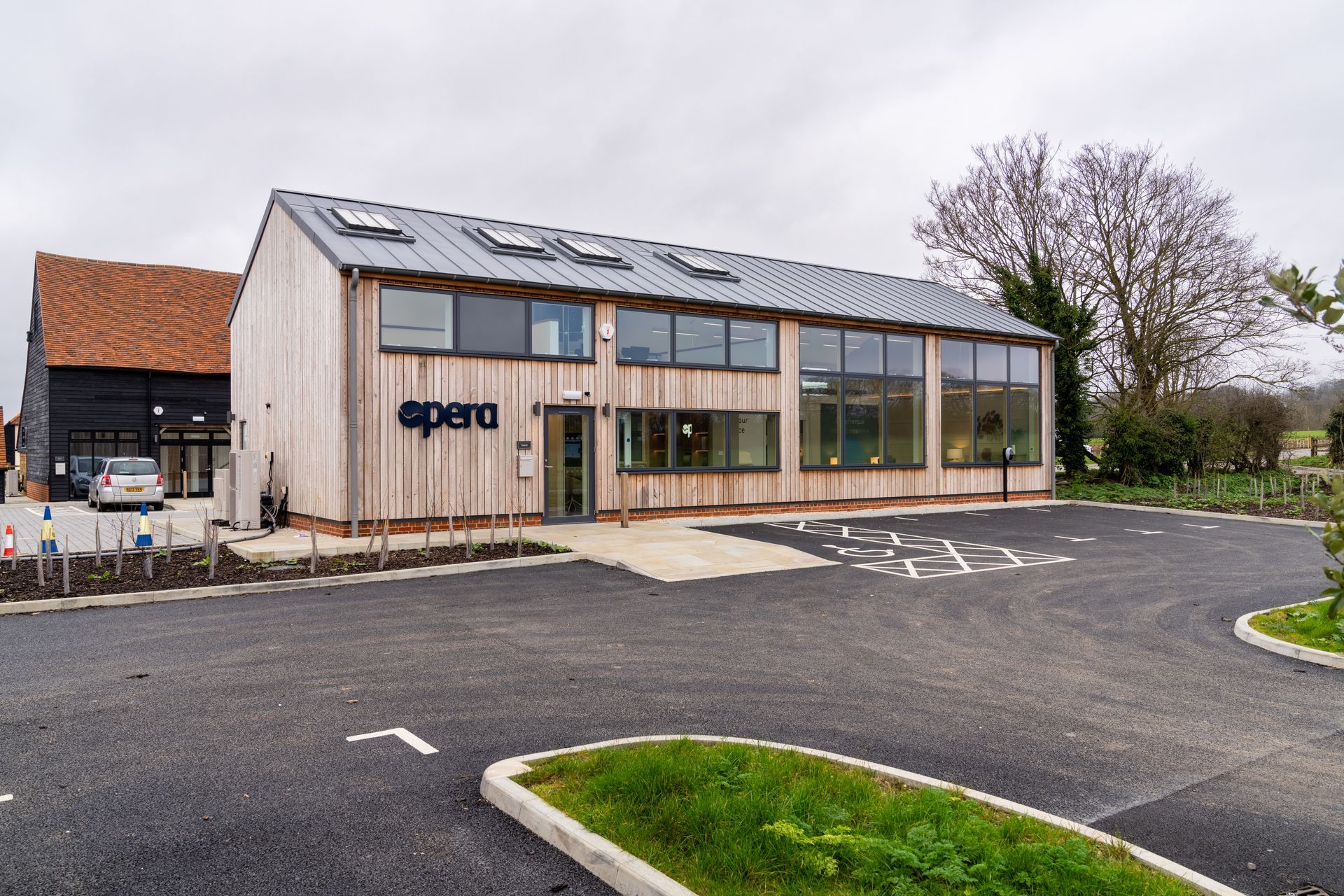 A large wooden building with a parking lot in front of it.
