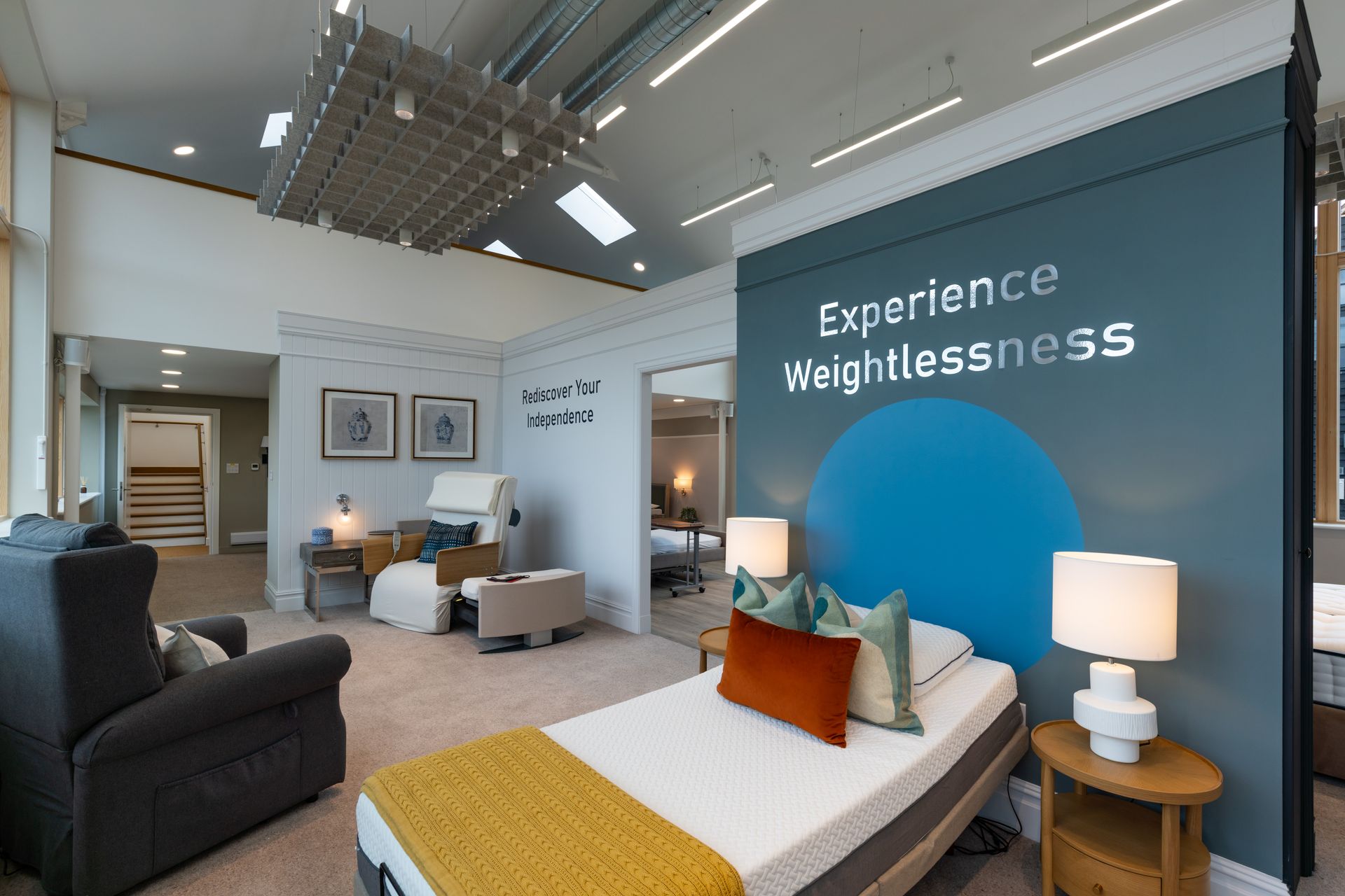 A room with a bed, chairs, lamps and a wall that says `` experience weightlessness ''. Specialist nursing care beds