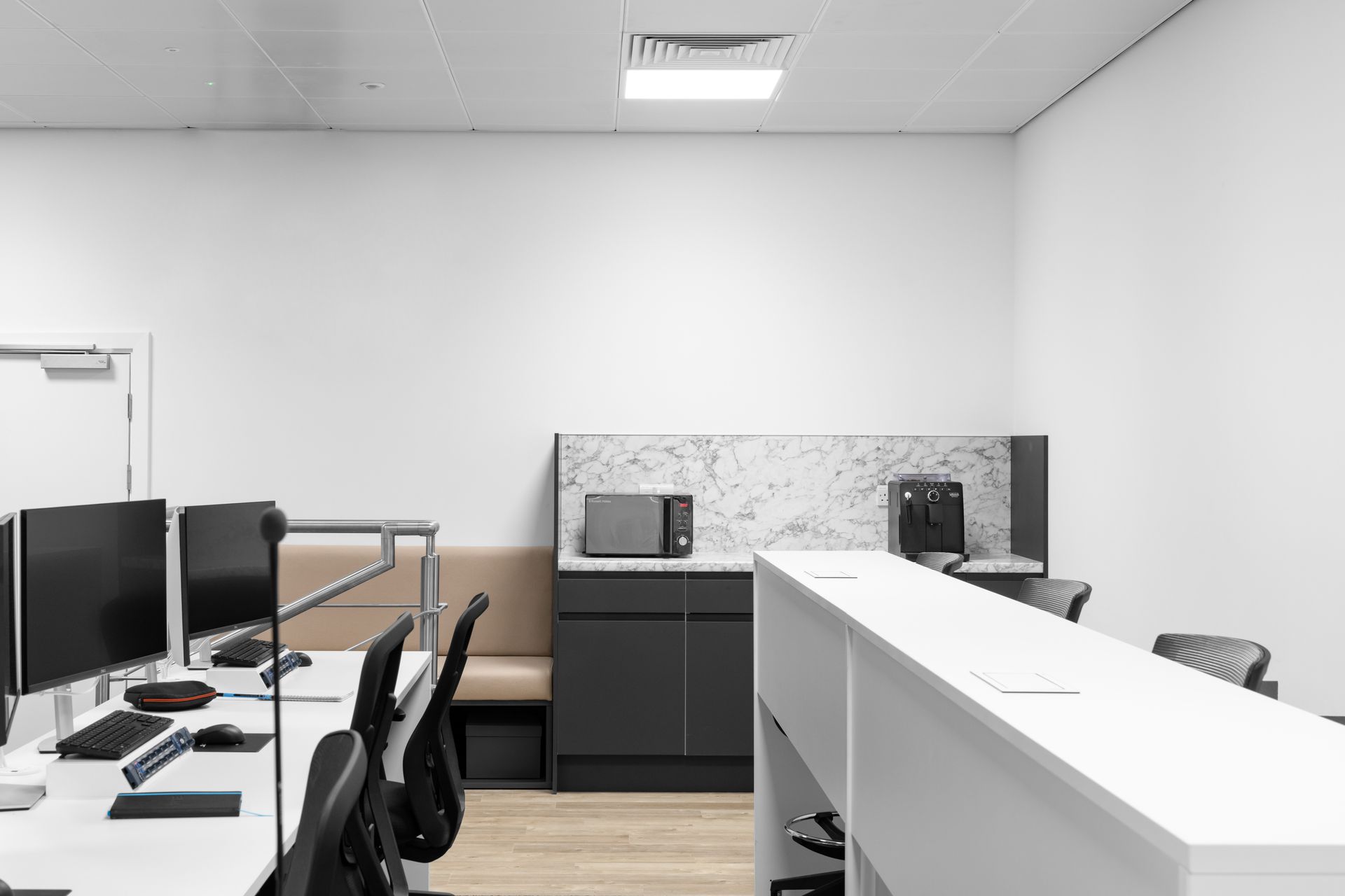 a room with a long table and a microwave on the wall .