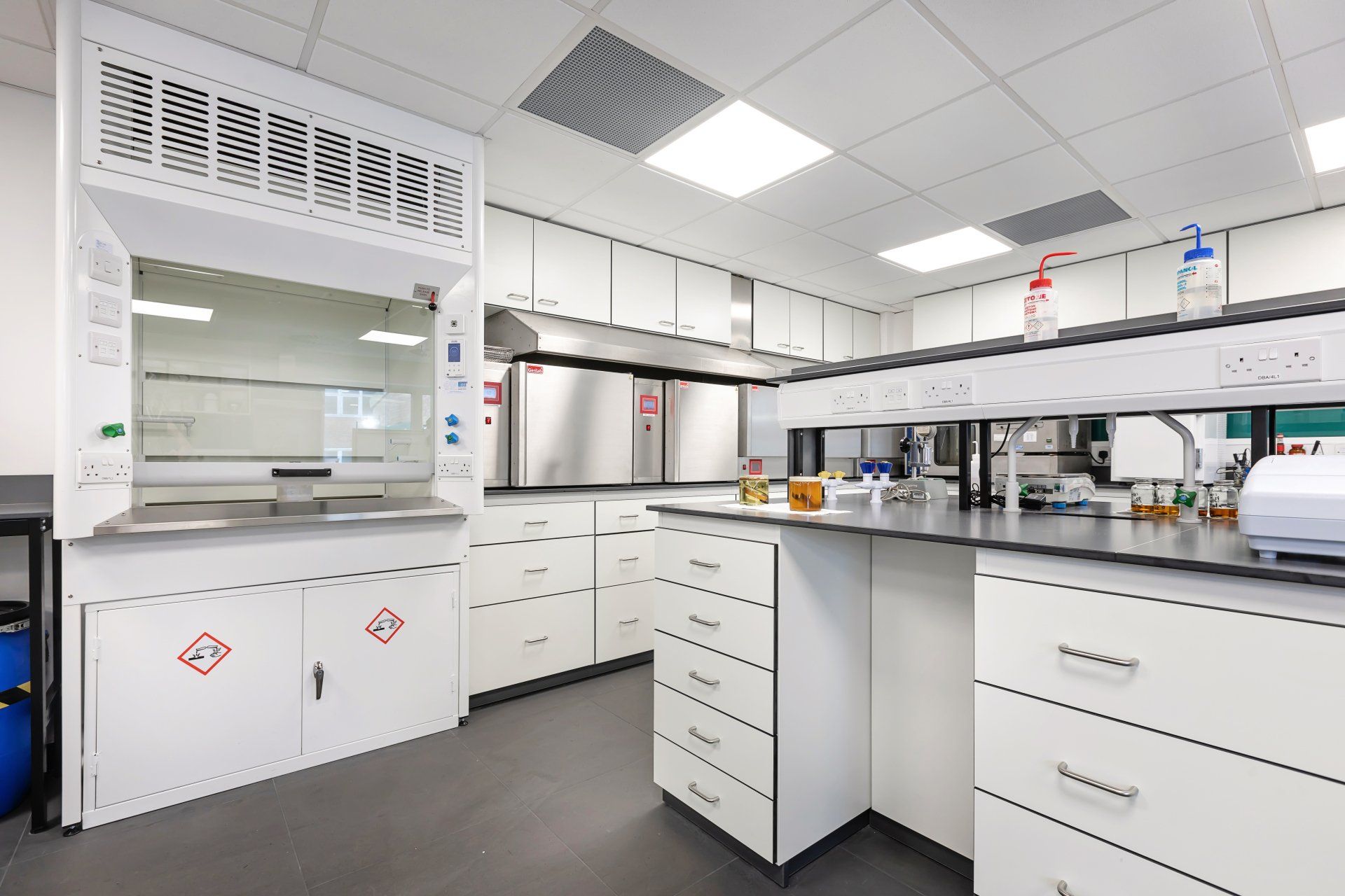 A laboratory with white cabinets and stainless steel appliances