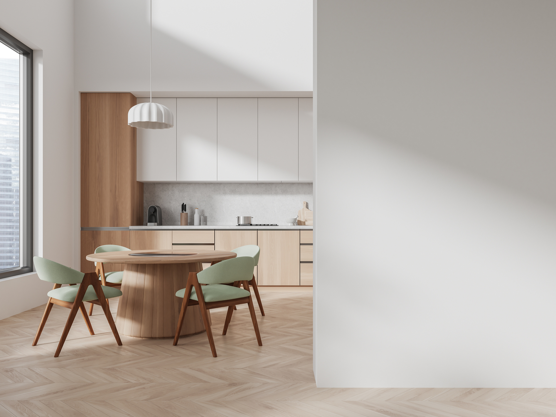 A dining table with mint green chairs in front of a modern kitchen with light wood cabinets and white upper cabinets.