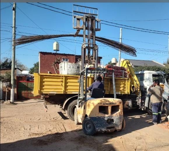 Un camión amarillo con una carretilla elevadora acoplada.