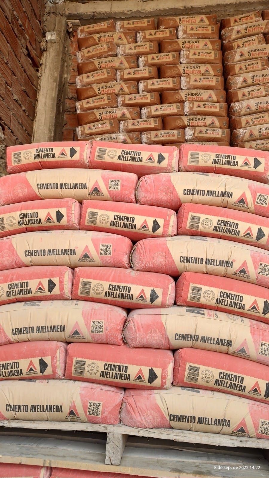 Una pila de bolsas de cemento apiladas una encima de otra.