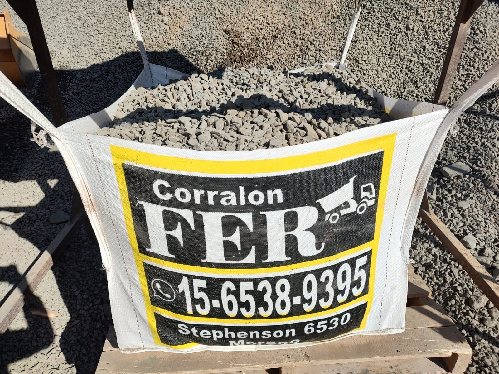 Una bolsa de tierra está sobre una mesa de madera con el número 15-6538-9393 en ella