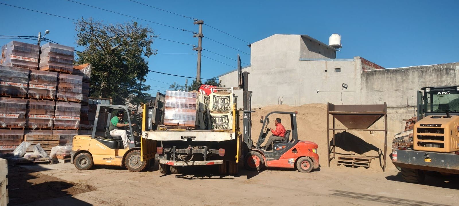 Una carretilla elevadora está cargando ladrillos en un camión.