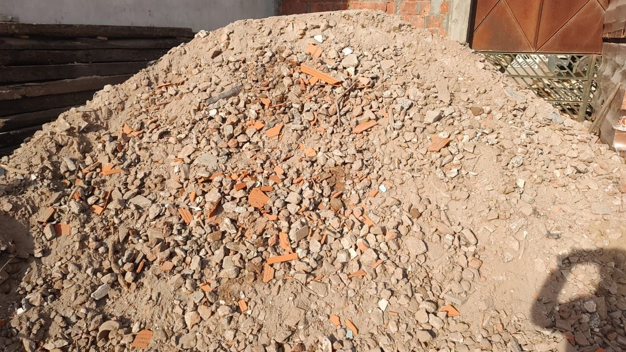 Un montón de tierra y ladrillos se encuentra frente a un edificio.