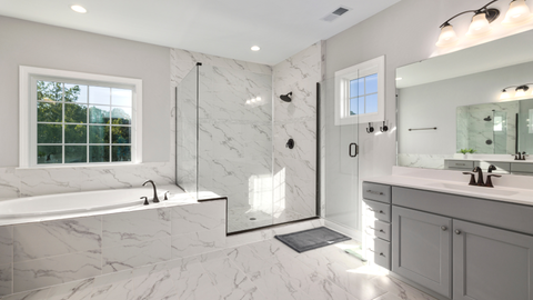 Modern bathroom with white marble tile, a soaking tub, a glass-enclosed shower, and a grey vanity with a large mirror.