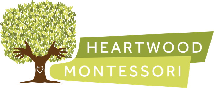 The logo for heartwood montessori shows a tree with a heart on it.