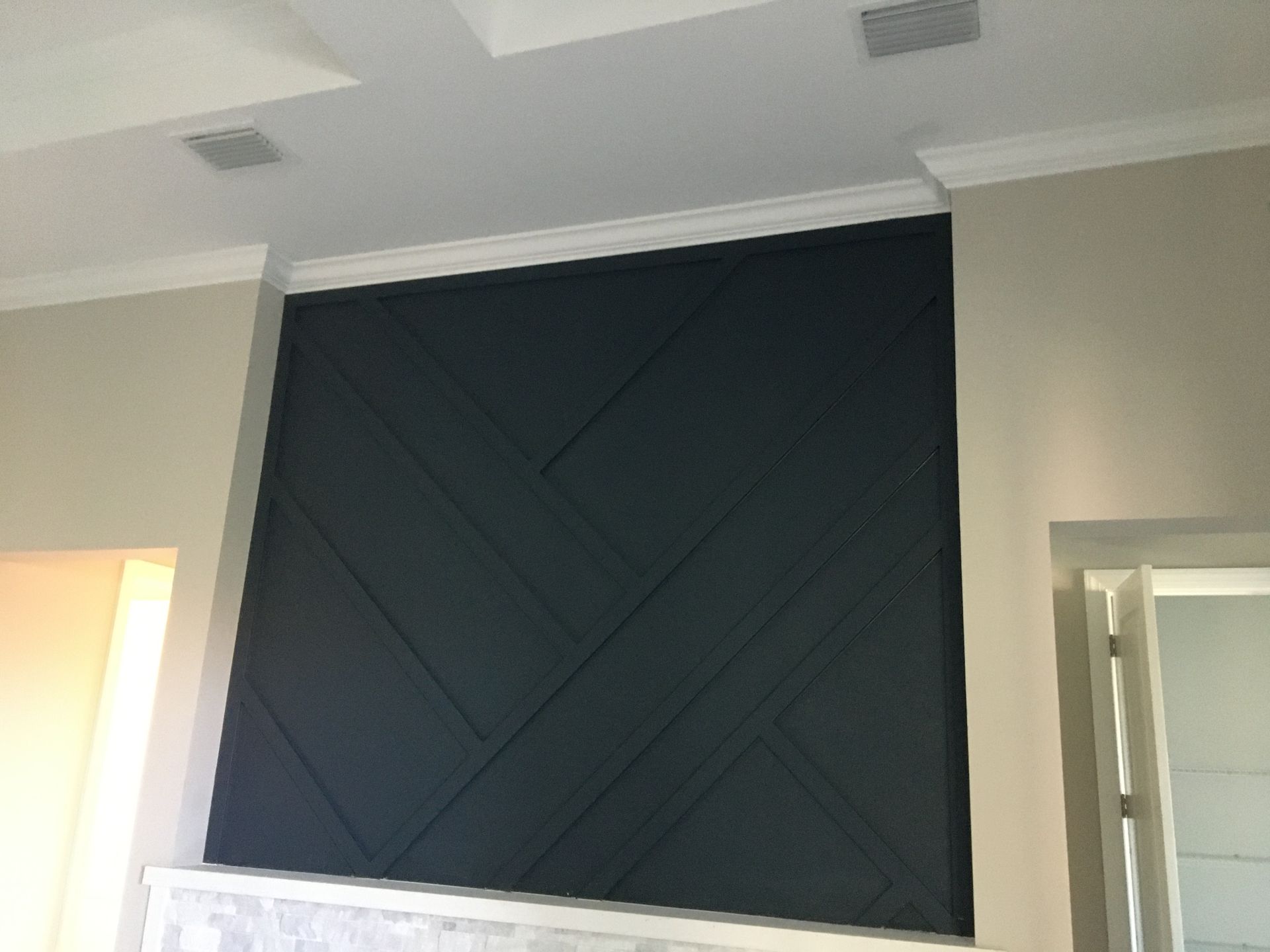 Dark accent wall with custom paneling, showcasing residential interior painting services for a modern design.
