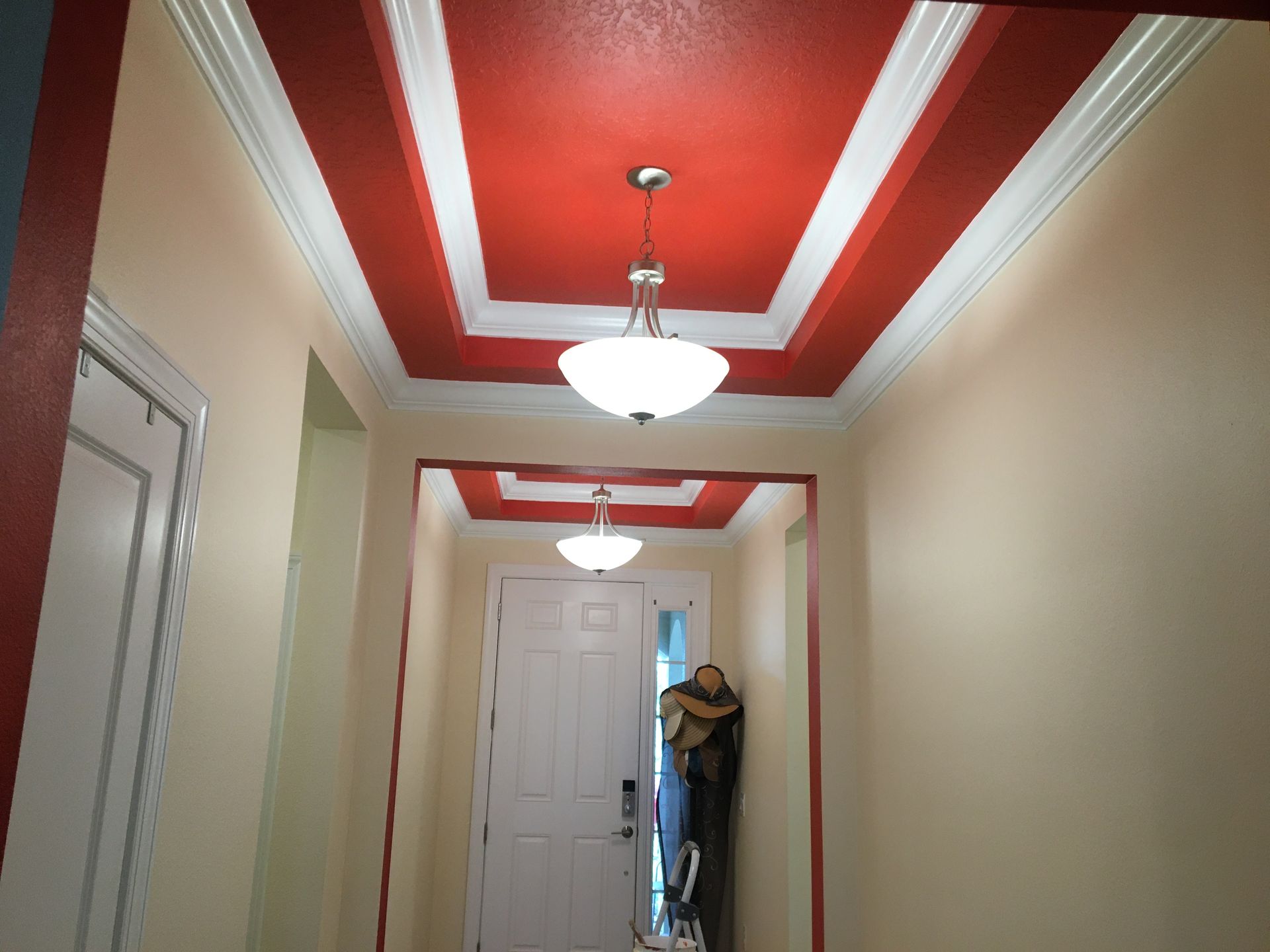 Hallway with a striking red and white ceiling design, featuring interior residential painting services for a custom look.