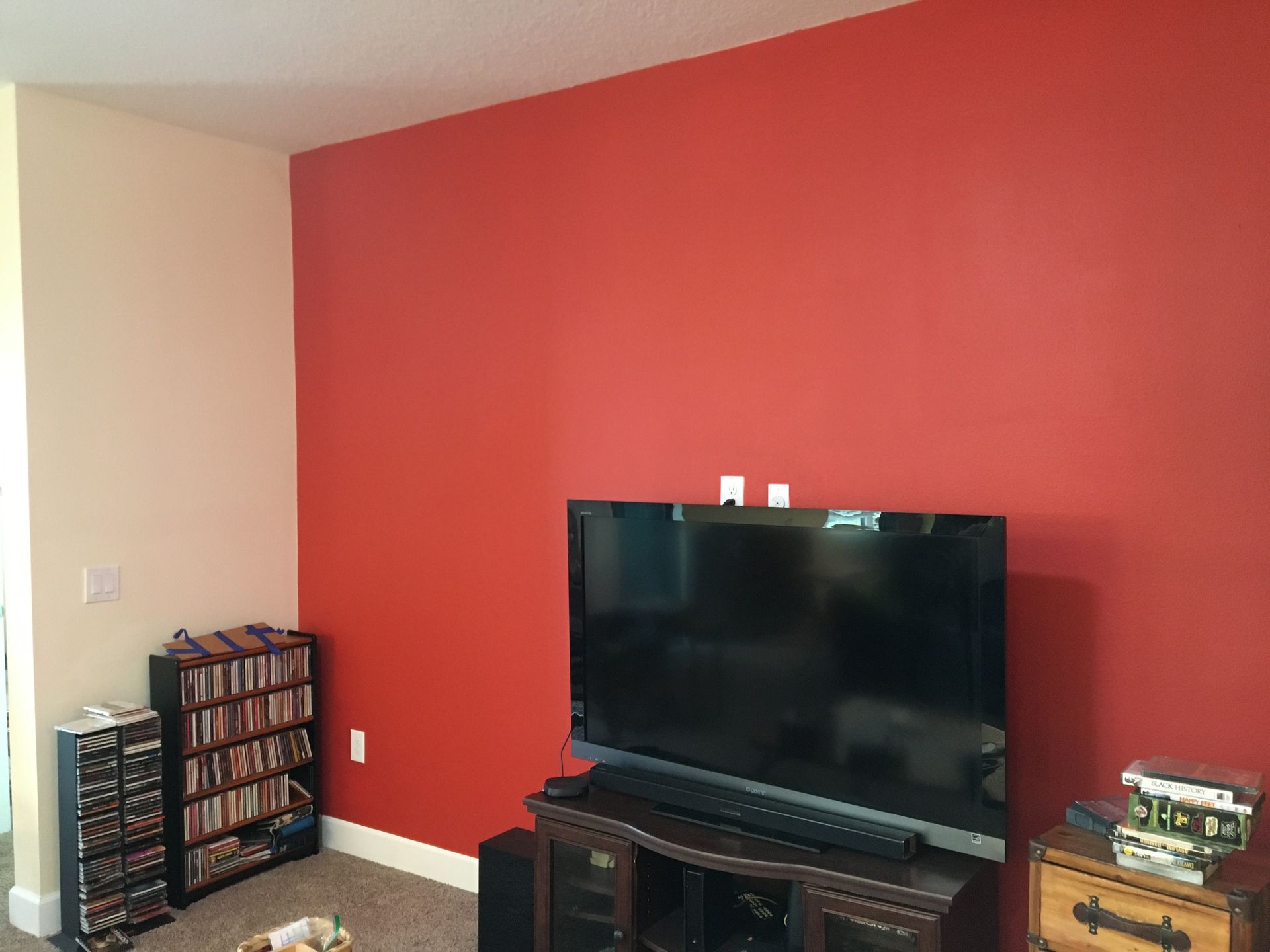 Living room with a bold red accent wall featuring residential painting services for a modern interior update.