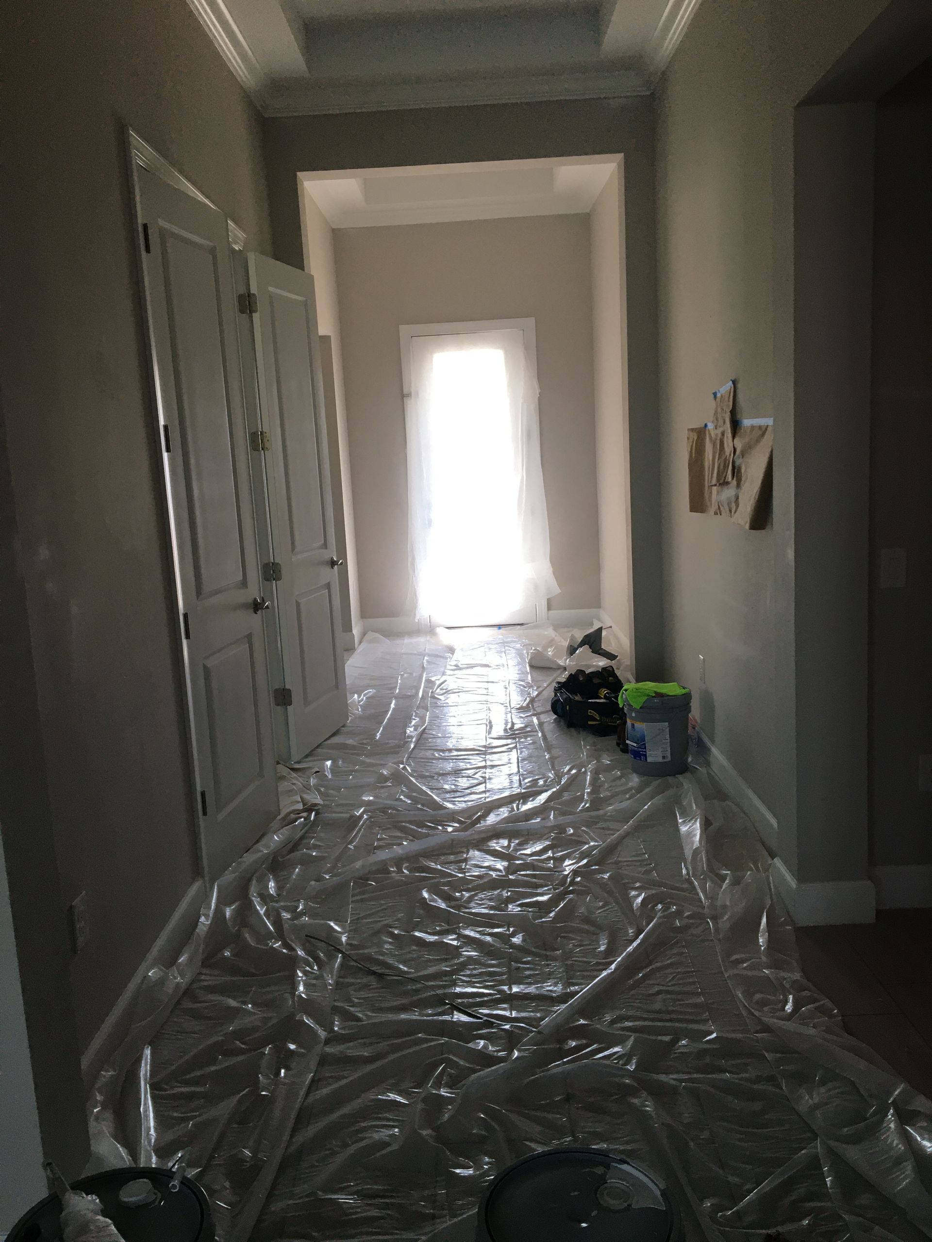 Interior hallway prepared for residential exterior painting services, with floors covered for protection.