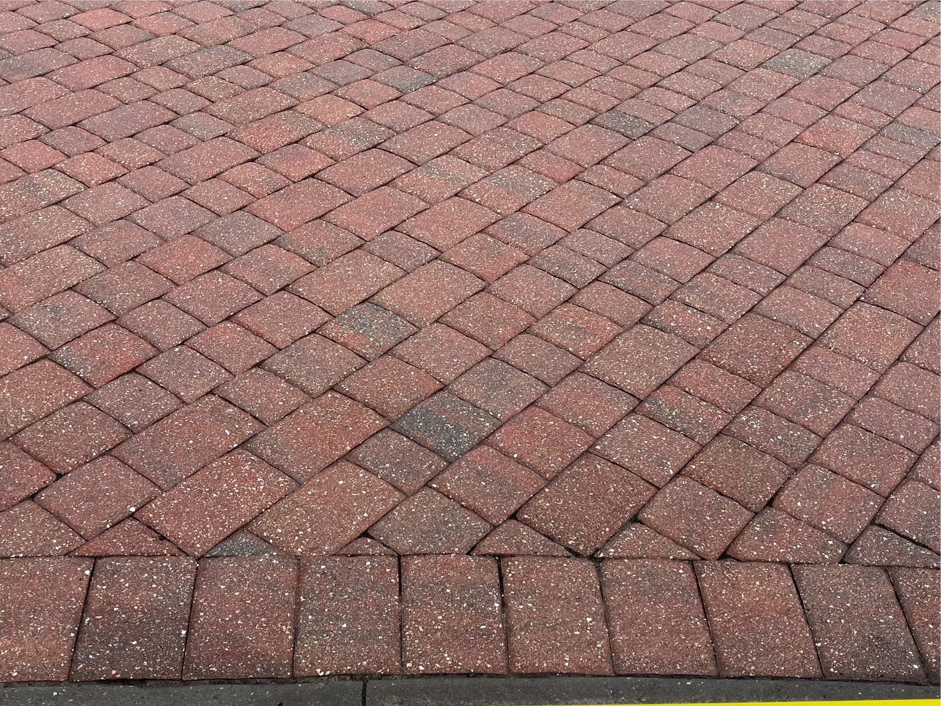 Close-up of a brick driveway after paver sealing, enhancing durability and color protection.