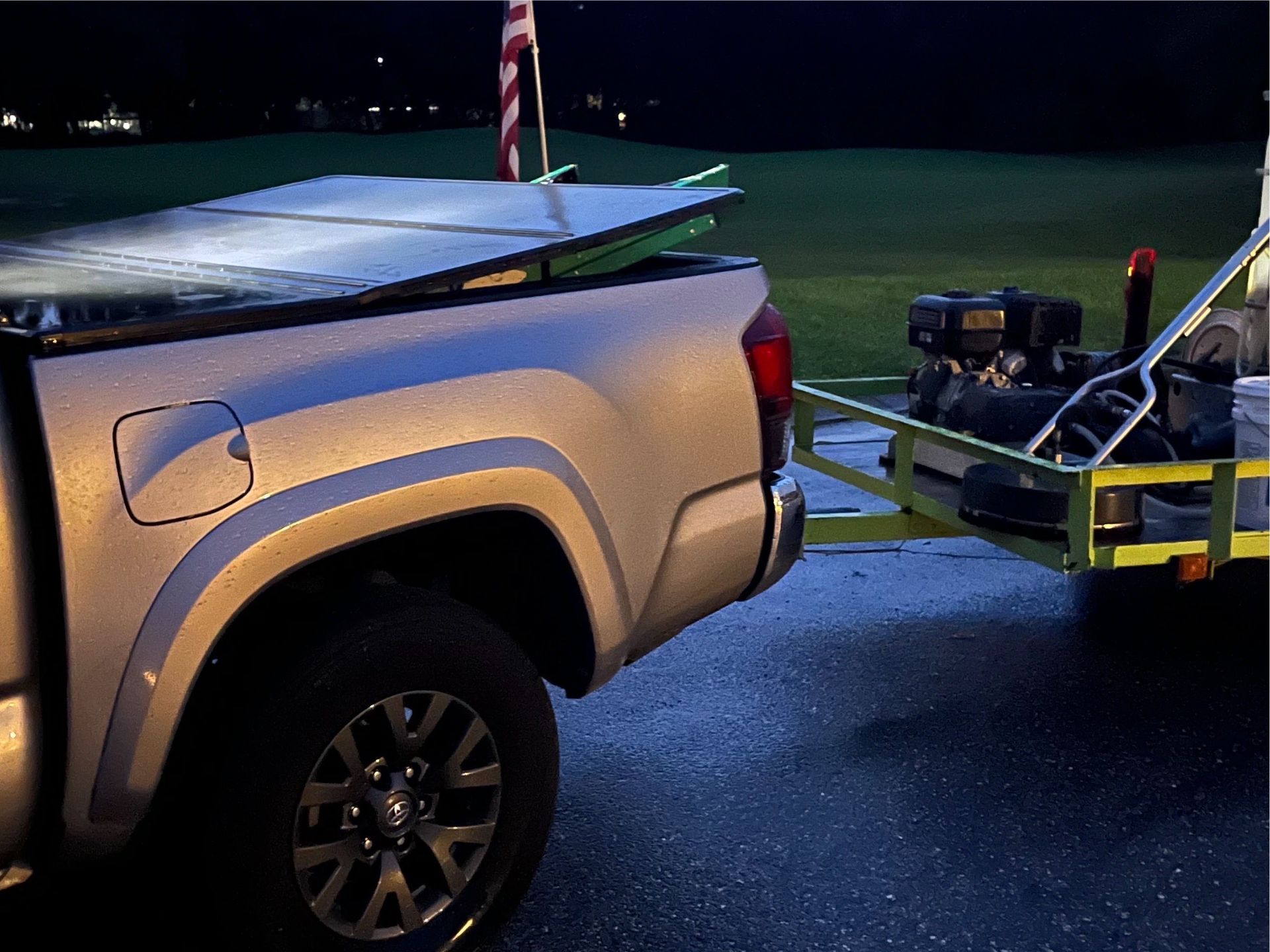 A truck is towing a trailer with a golf cart on it.