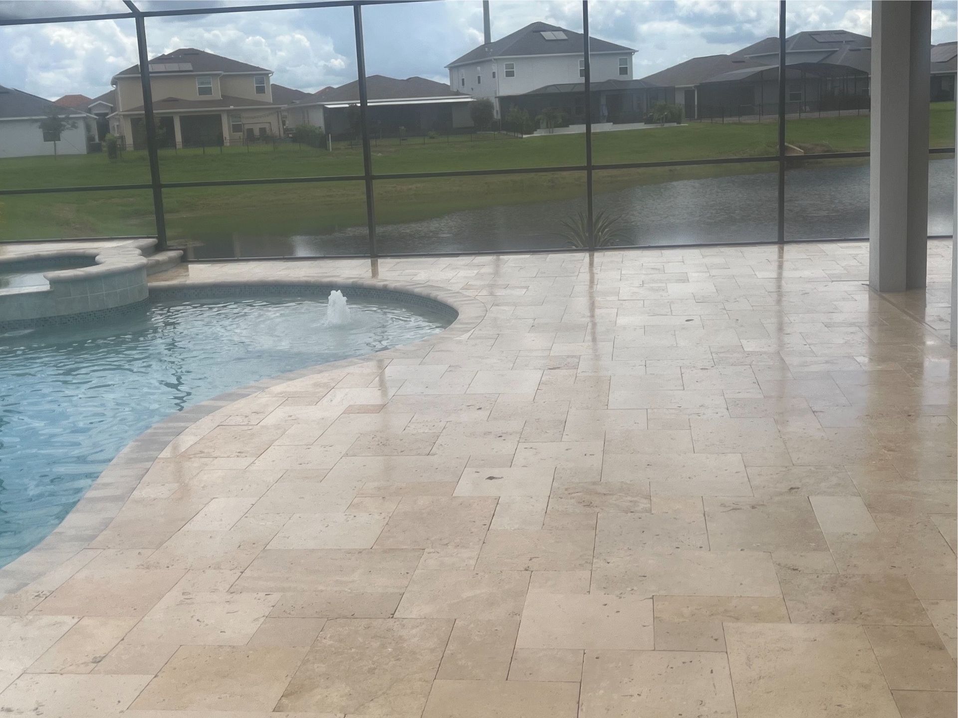 A swimming pool with a screened in area in the background