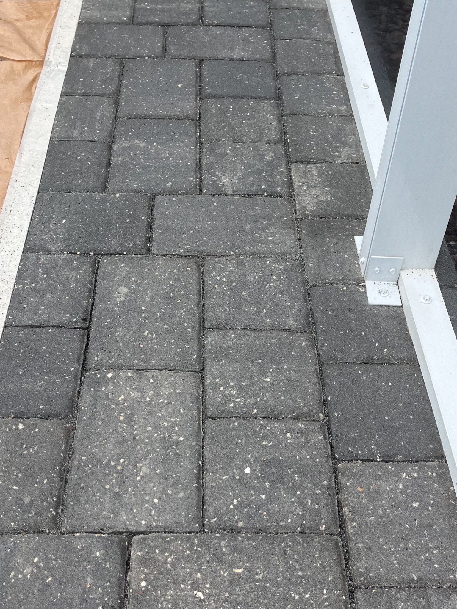 A close up of a brick walkway with a white border.