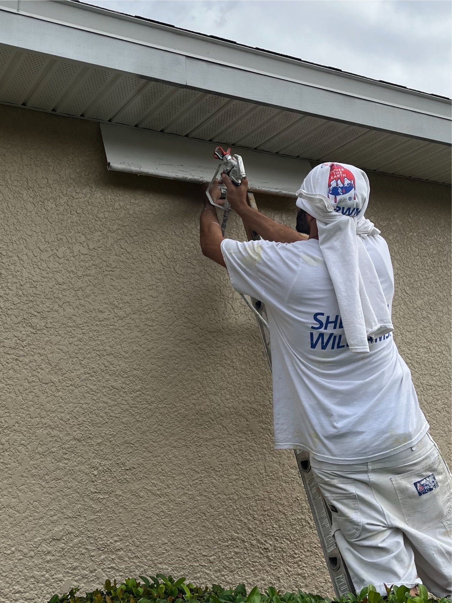 A man is painting the side of a house.