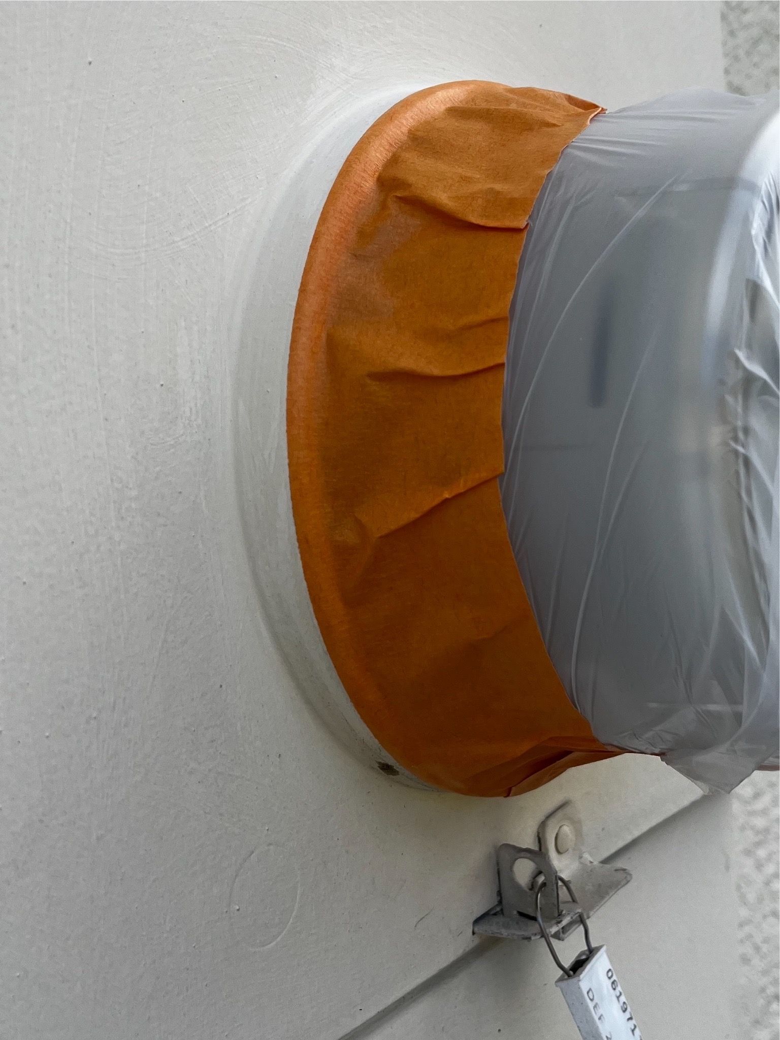 A piece of tape is covering a hole in a wall.