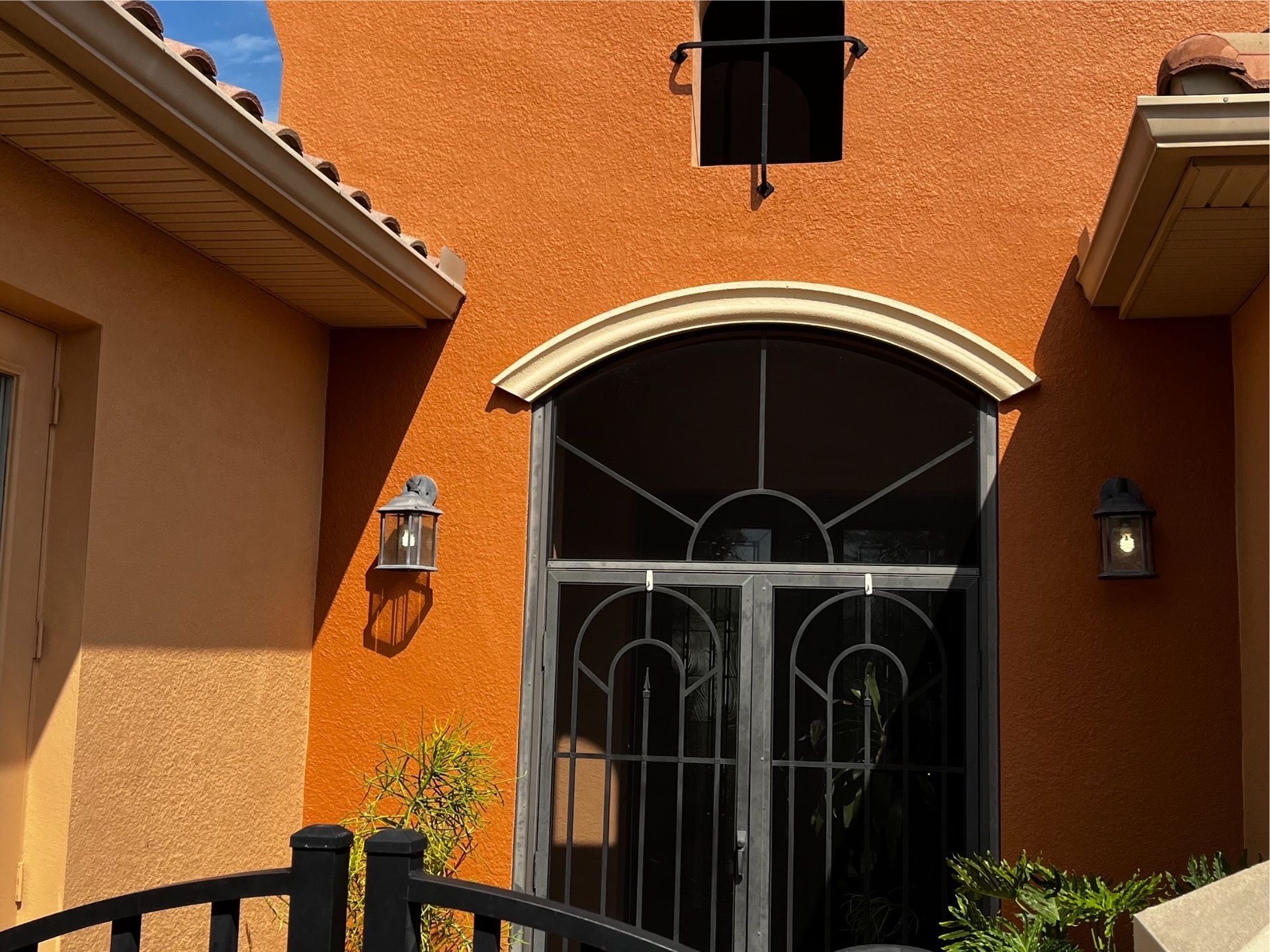 The front door of a house with a wrought iron gate