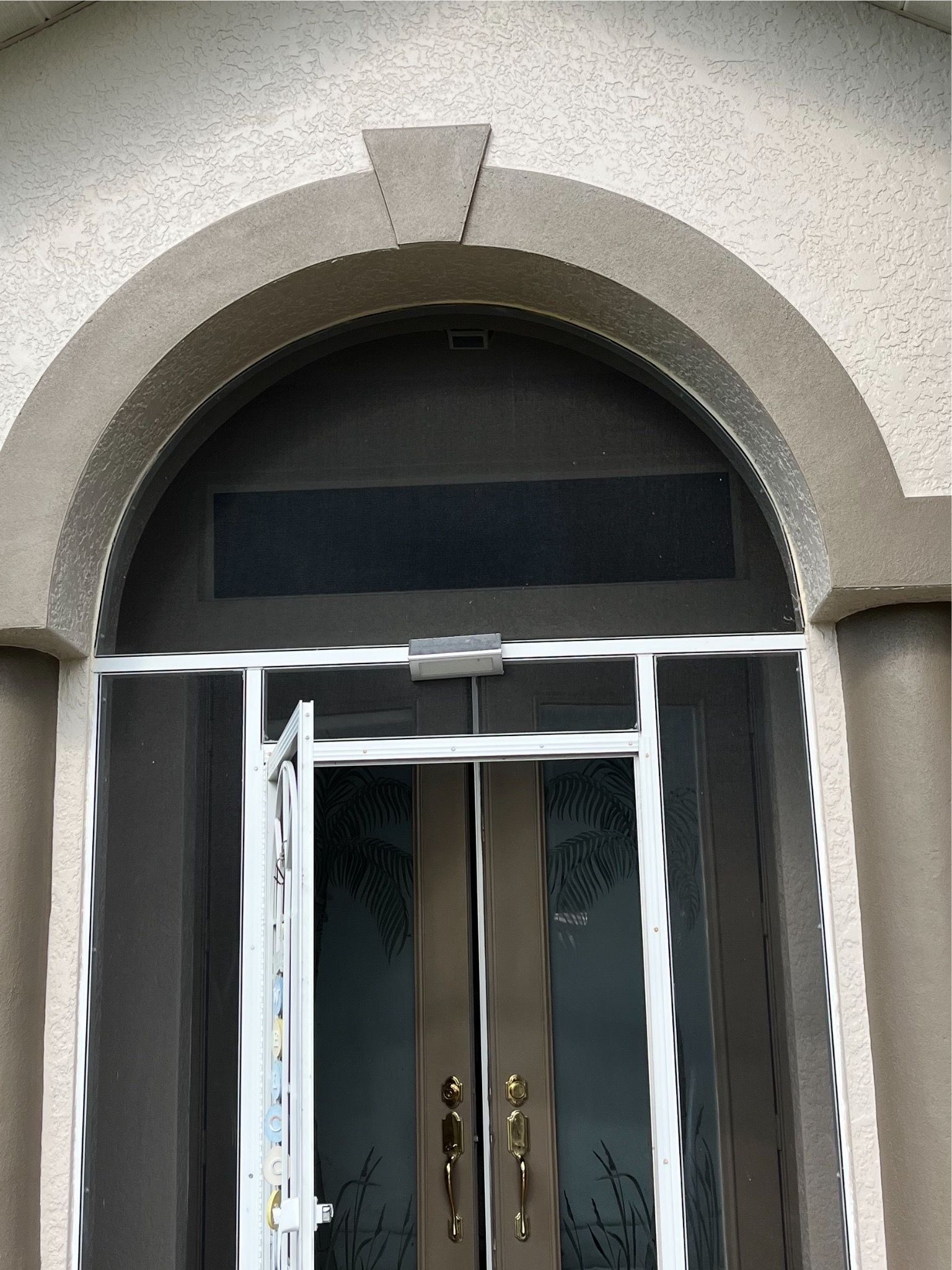 The front door of a house with a screen door