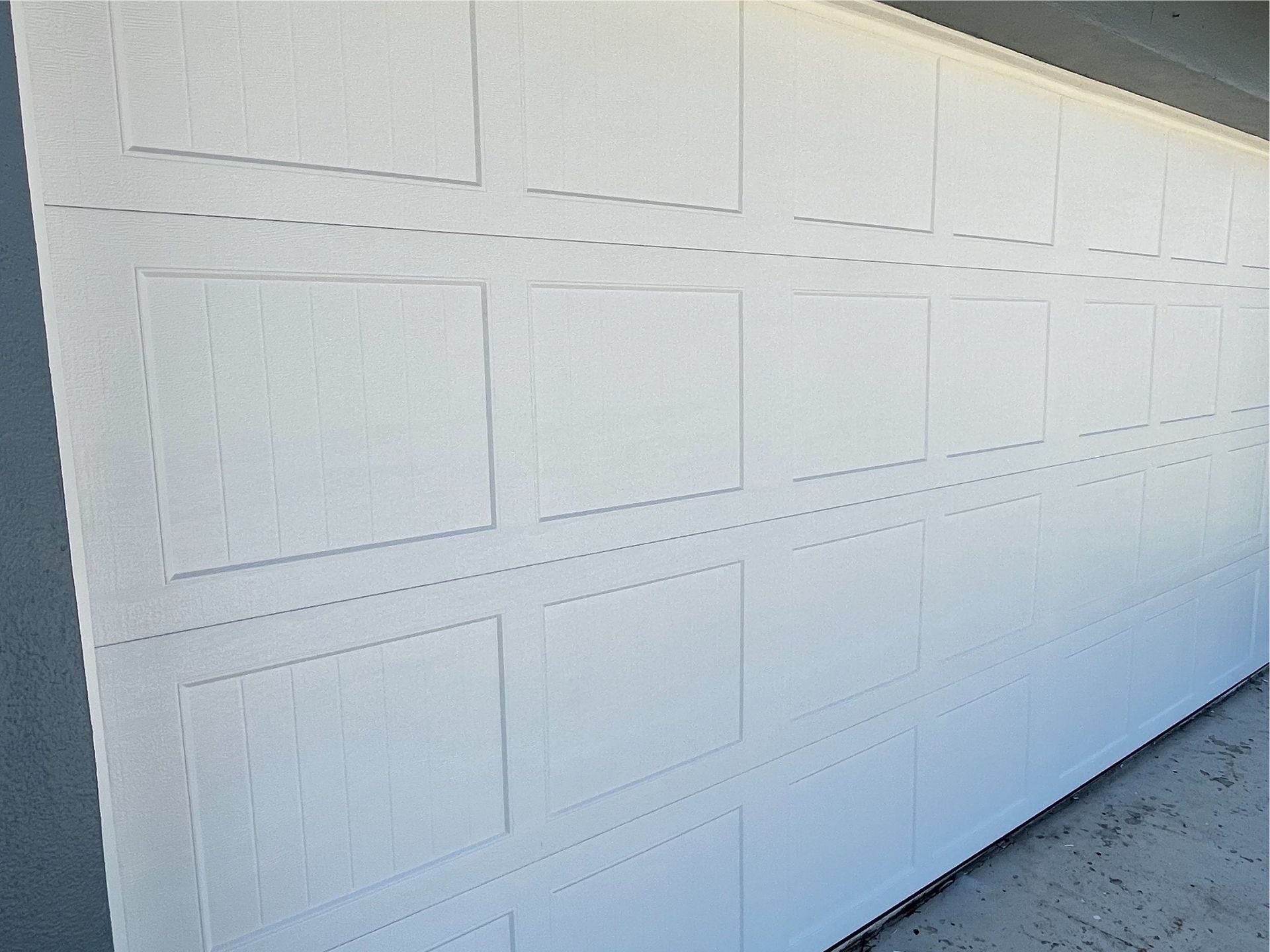 A close up of a white garage door with squares on it