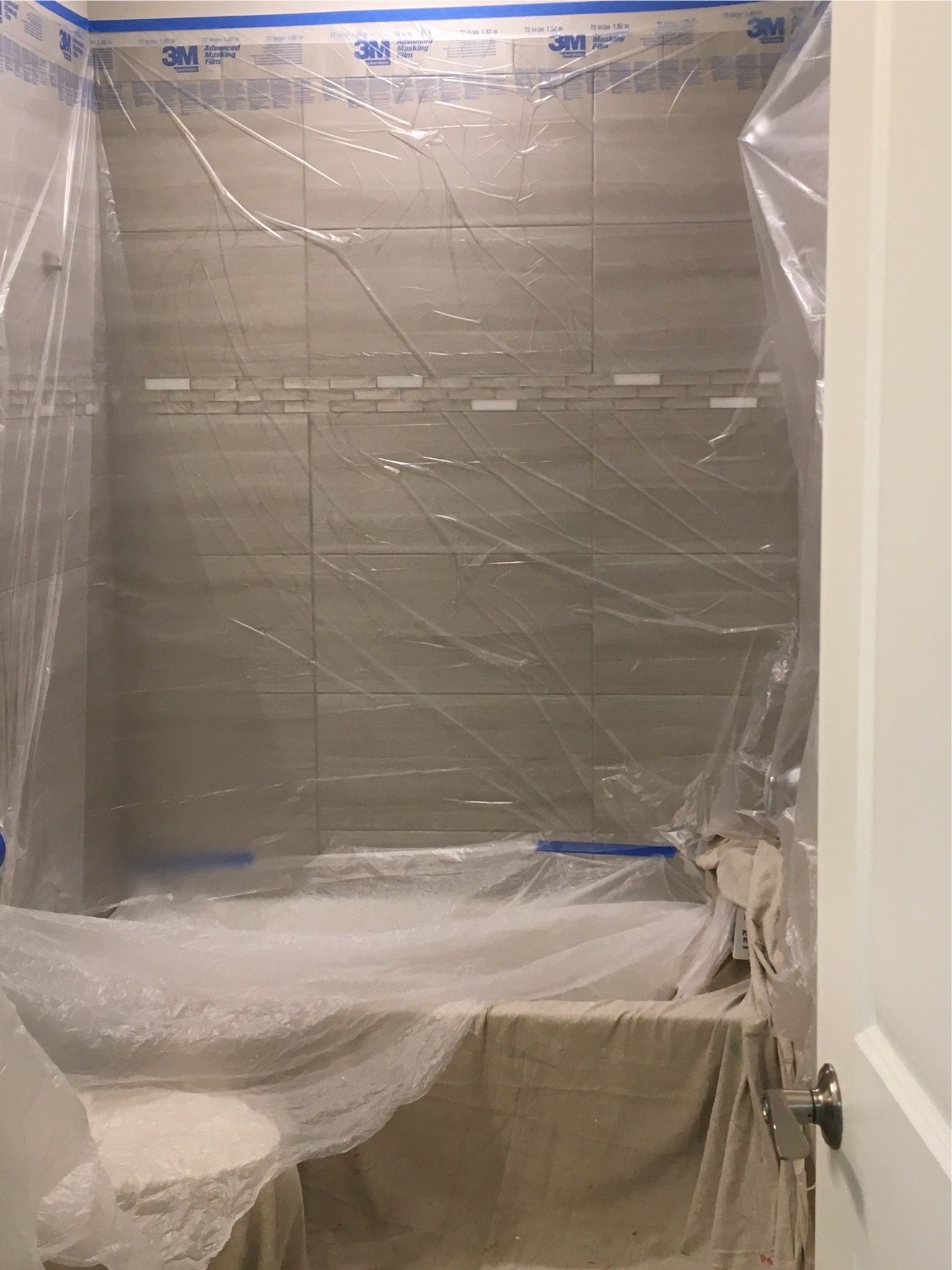 A bathroom is being remodeled and covered in plastic.