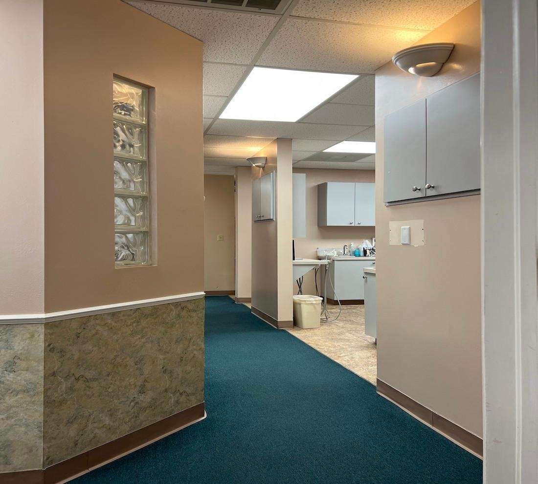 A hallway in a dental office with a blue carpet