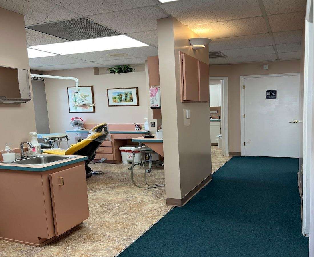 A dental office with a blue carpet and a dental chair