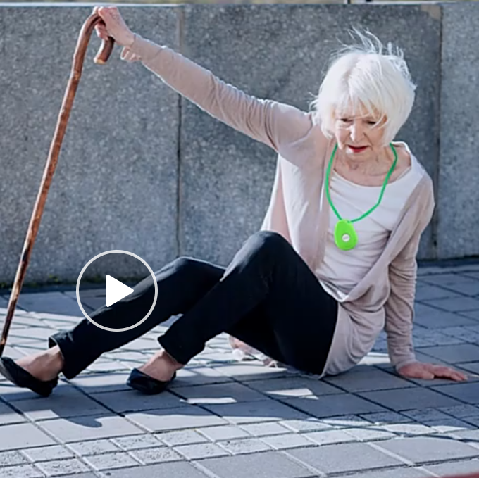 Een vrouw zit op de grond met een wandelstok in haar hand
