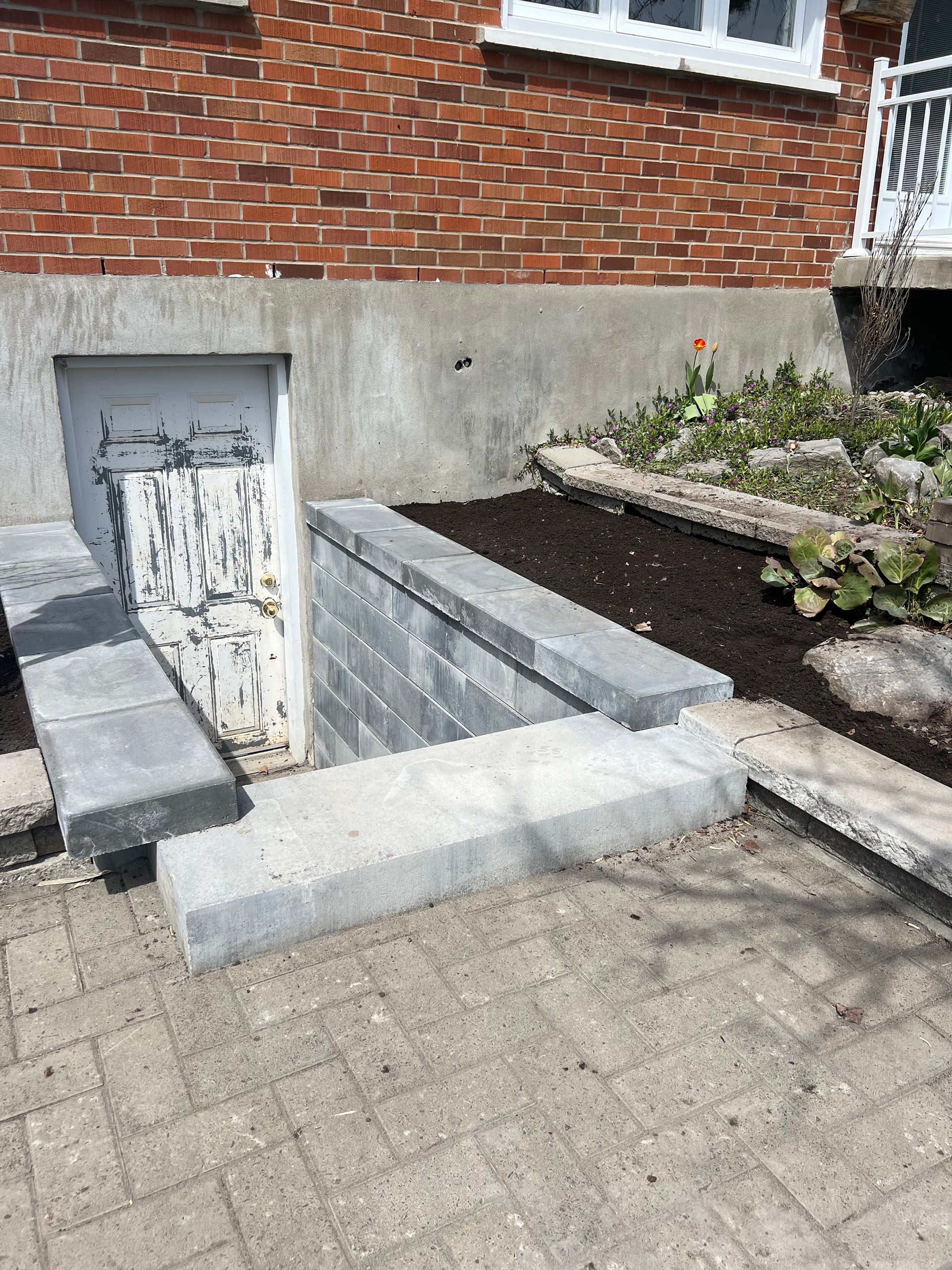 Un bâtiment en briques avec un escalier menant à un sous-sol.