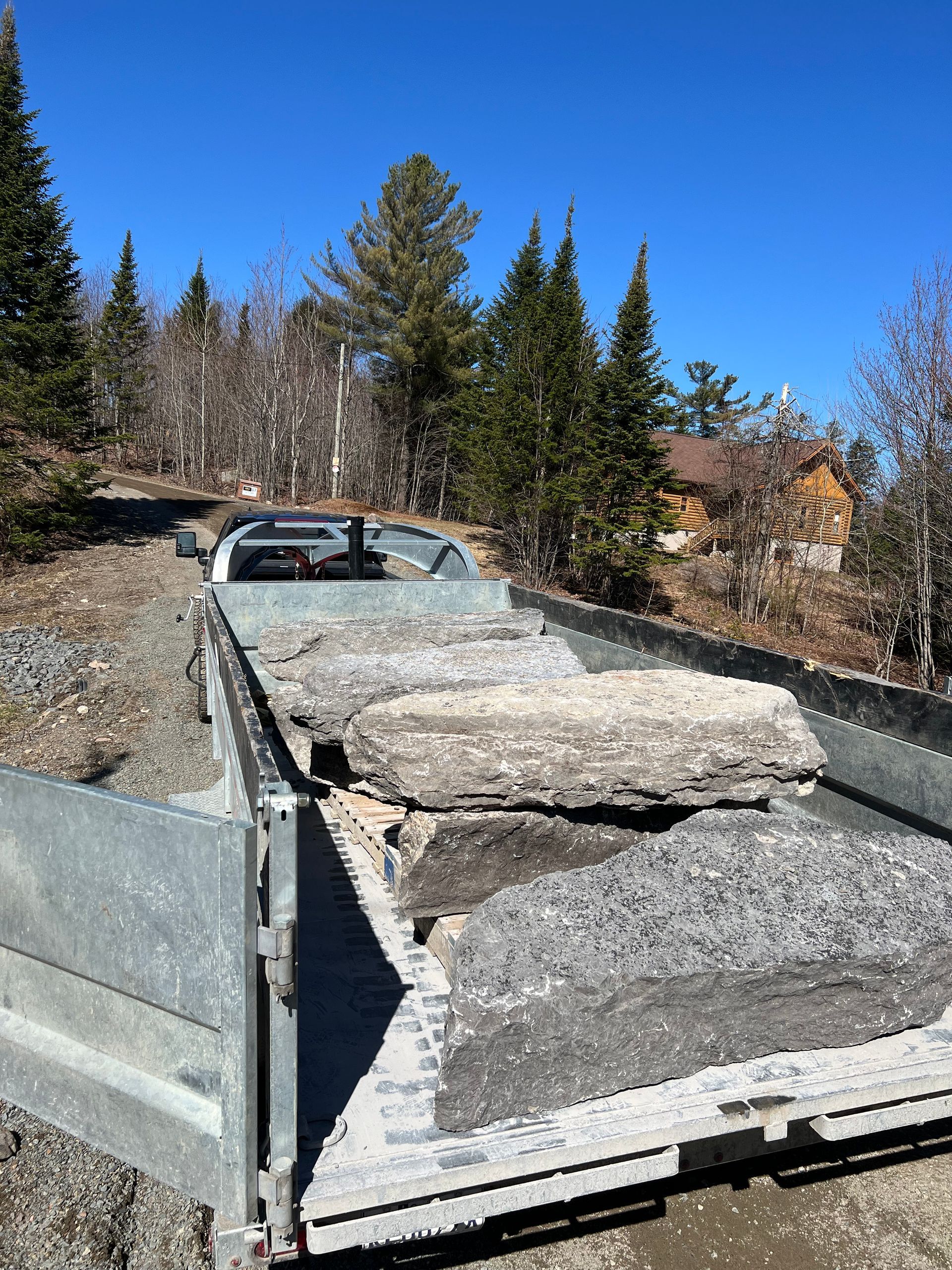 Un camion transporte une remorque remplie de pierres et de gravier.