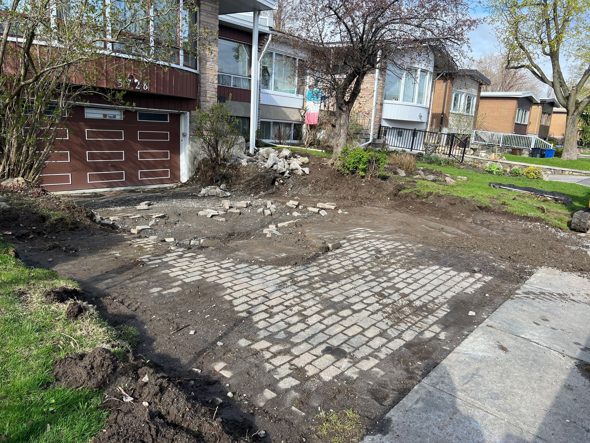 Une allée en briques est en cours de construction devant une maison.