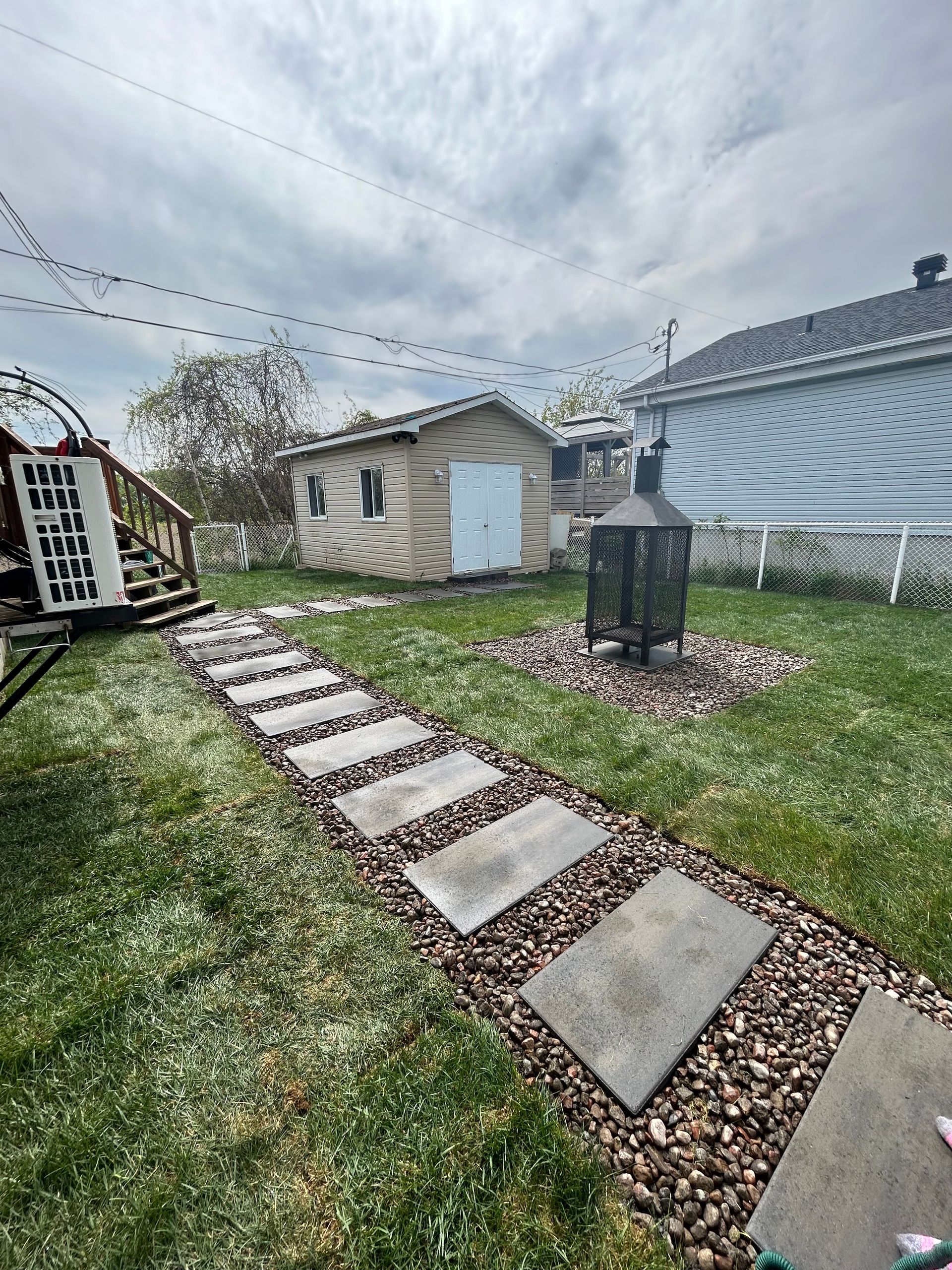 Une allée en pierre menant à un hangar dans une cour arrière.