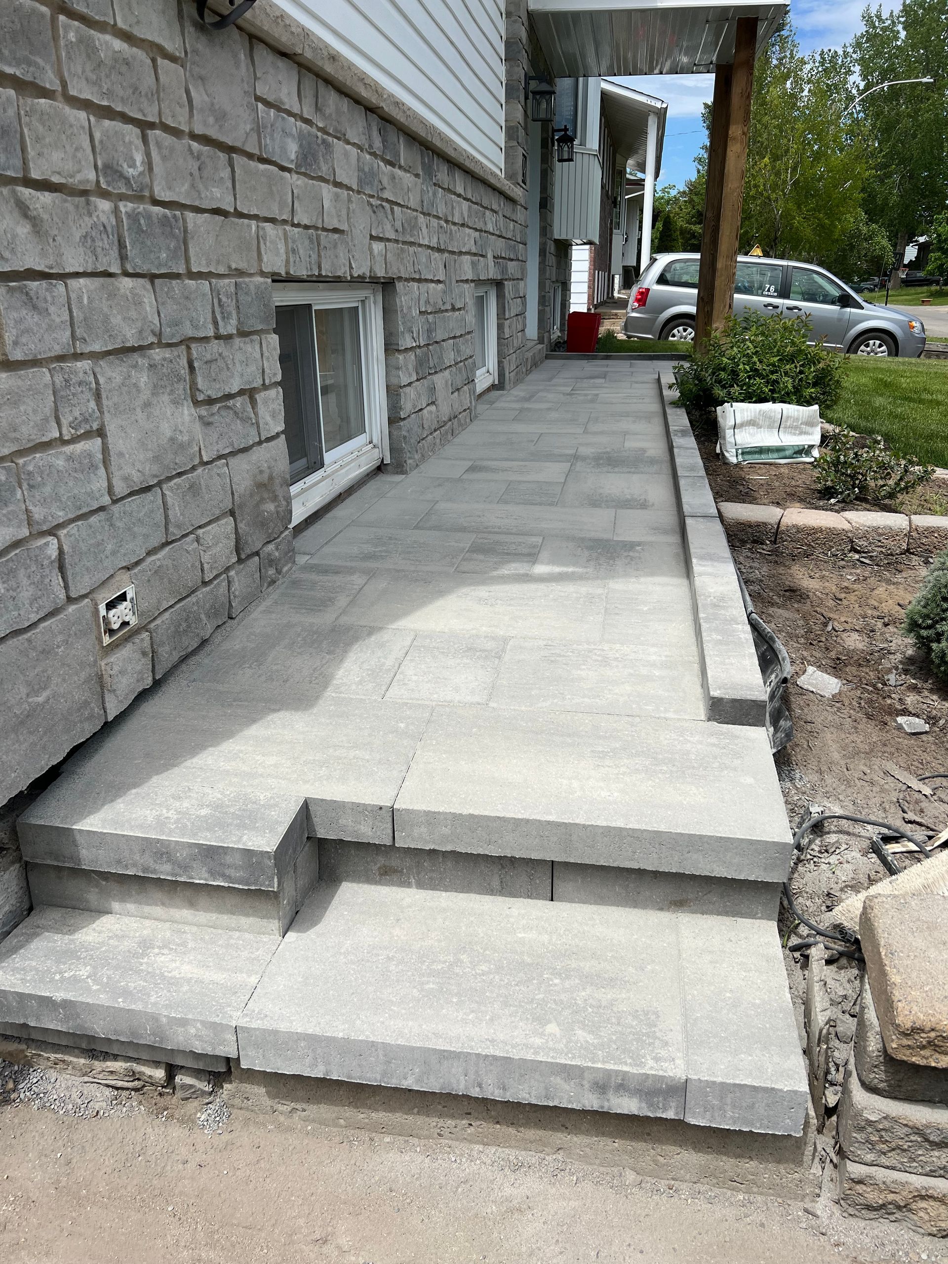 Une passerelle en béton est en cours de construction devant un bâtiment en briques.