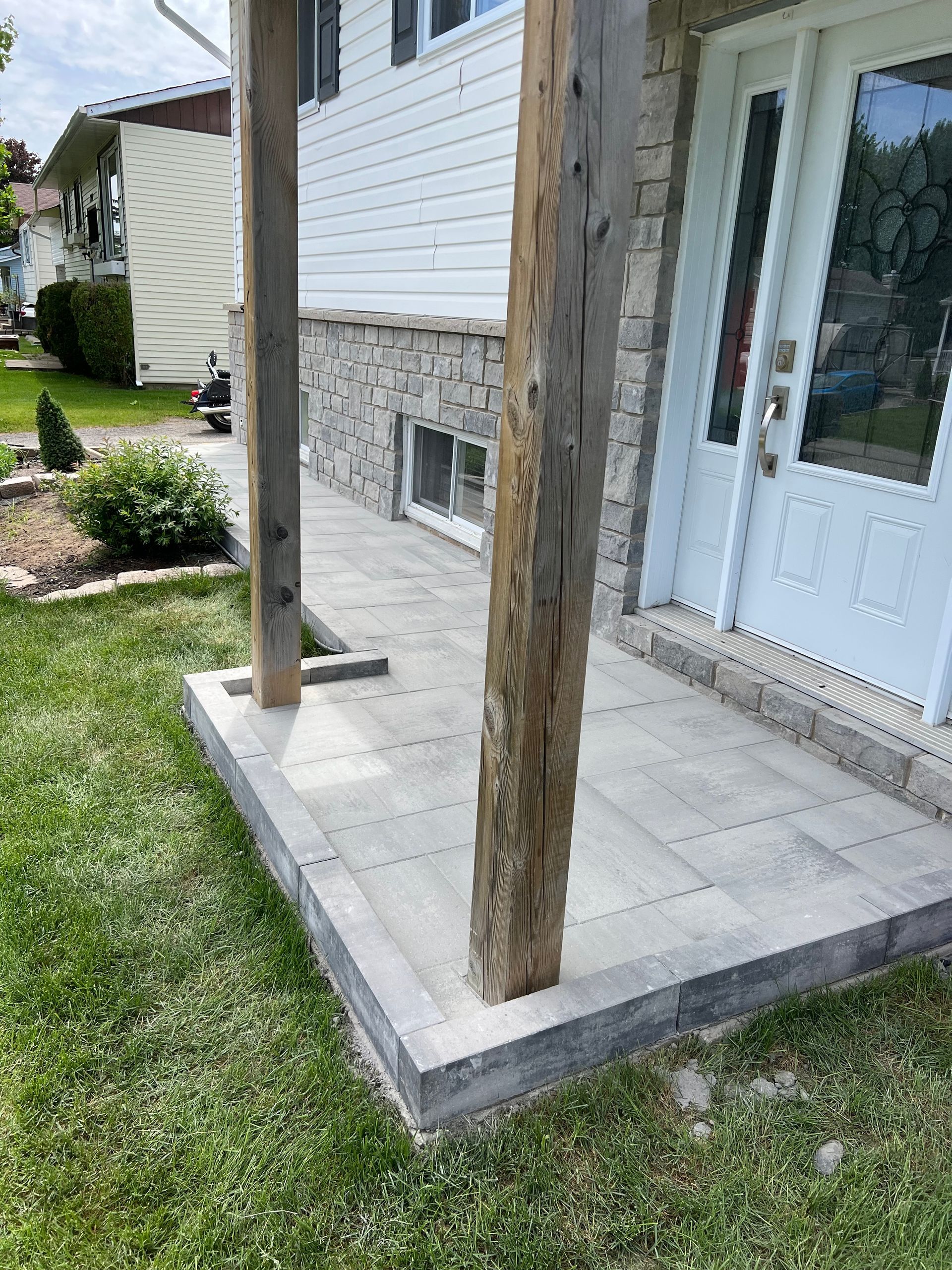 Un patio avec un poteau en bois devant une maison.