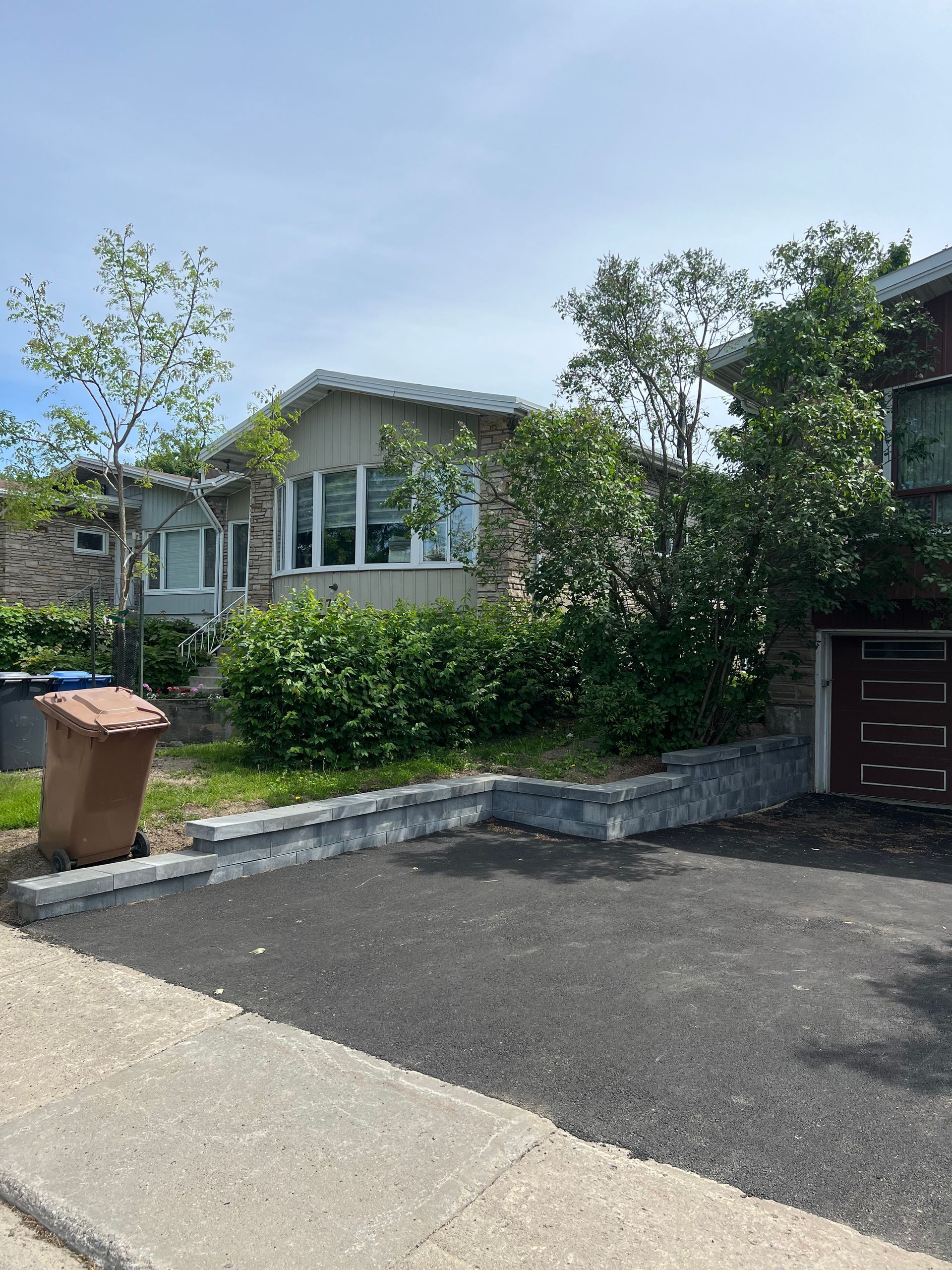 Il y a une poubelle devant une maison.