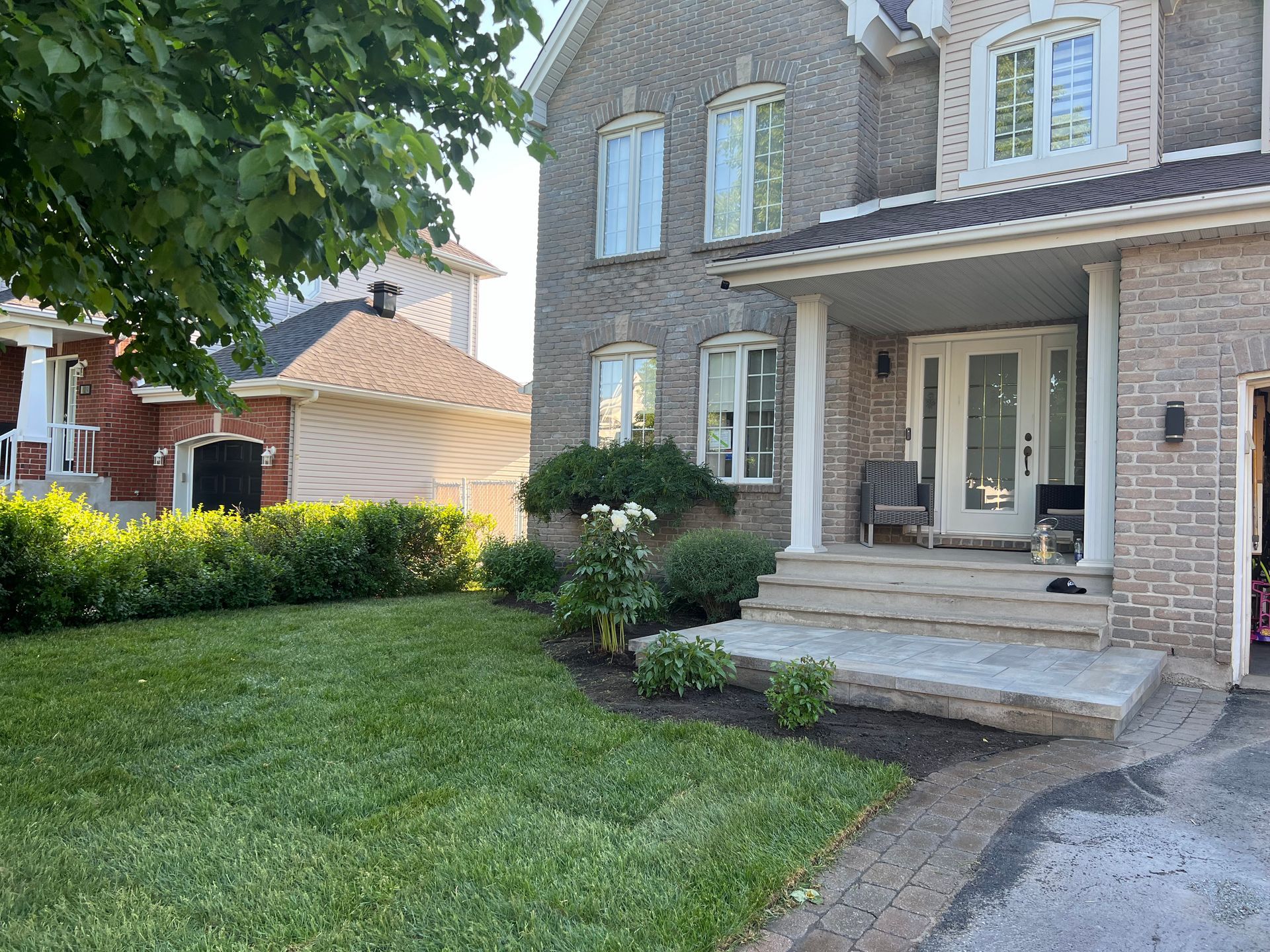 Une grande maison en briques avec une grande pelouse devant.
