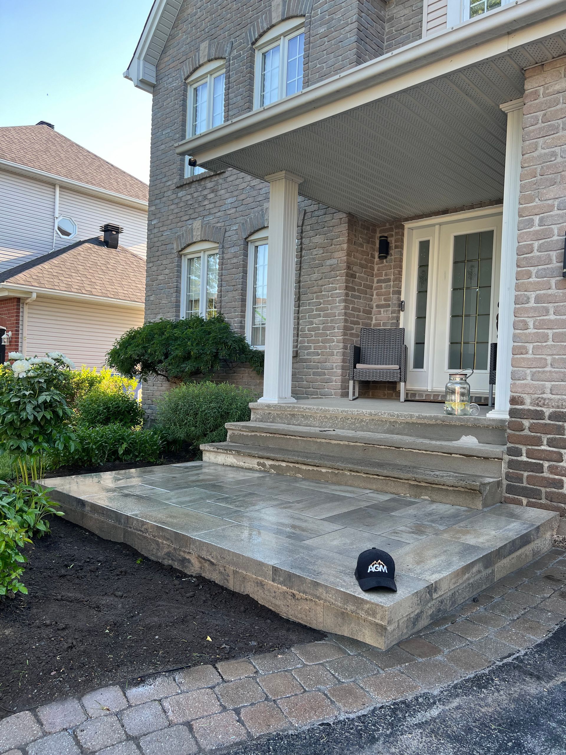 Une maison en brique avec un porche et des escaliers devant.