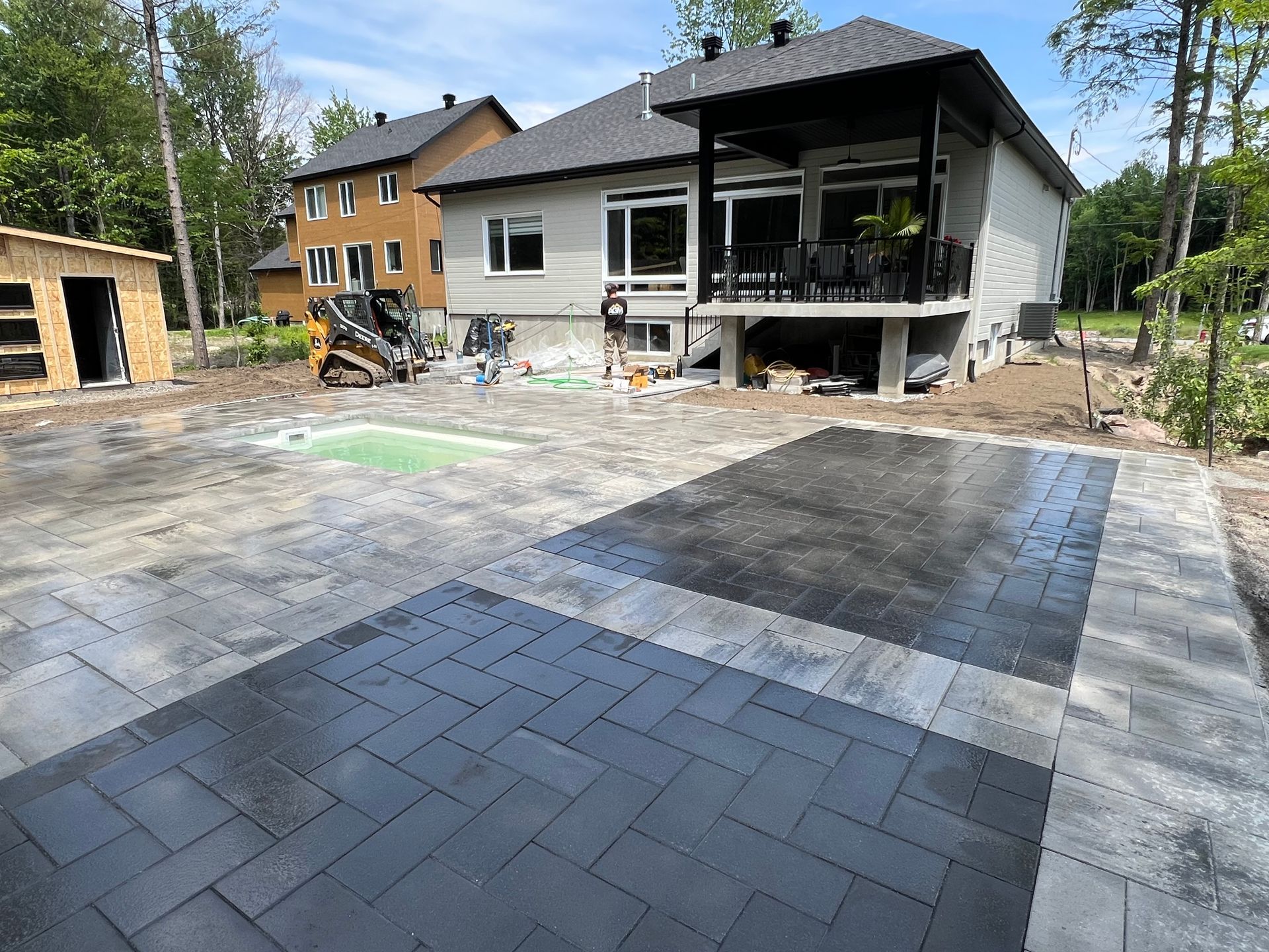 Une grande maison est en construction avec beaucoup de briques devant.