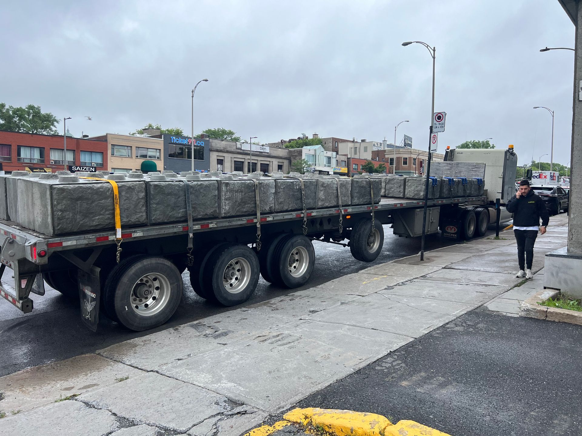 Un semi-remorque transportant des blocs de béton est garé sur le bord de la route.