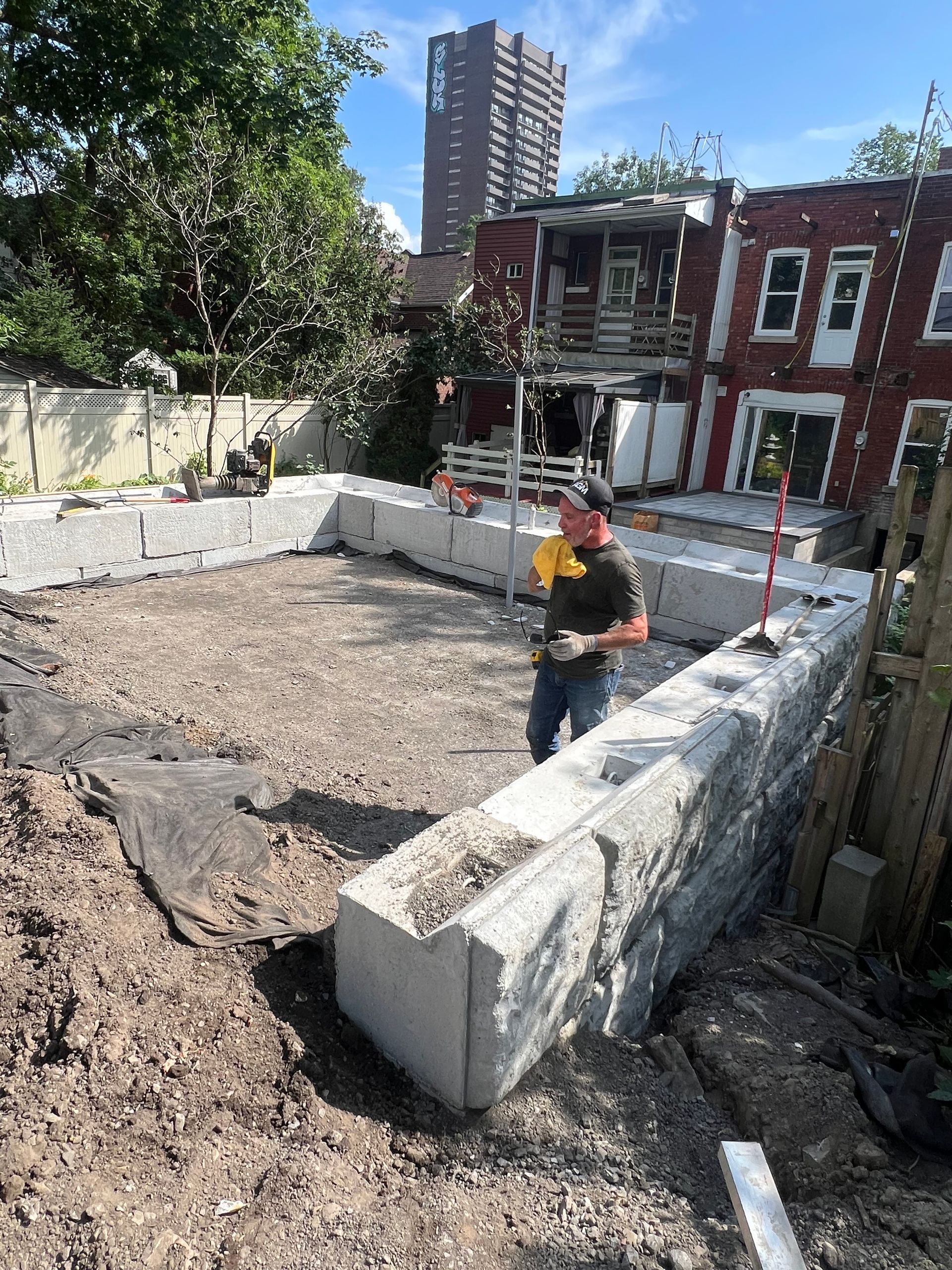 Un homme se tient debout à côté d'un gros bloc de béton sur un chantier de construction.