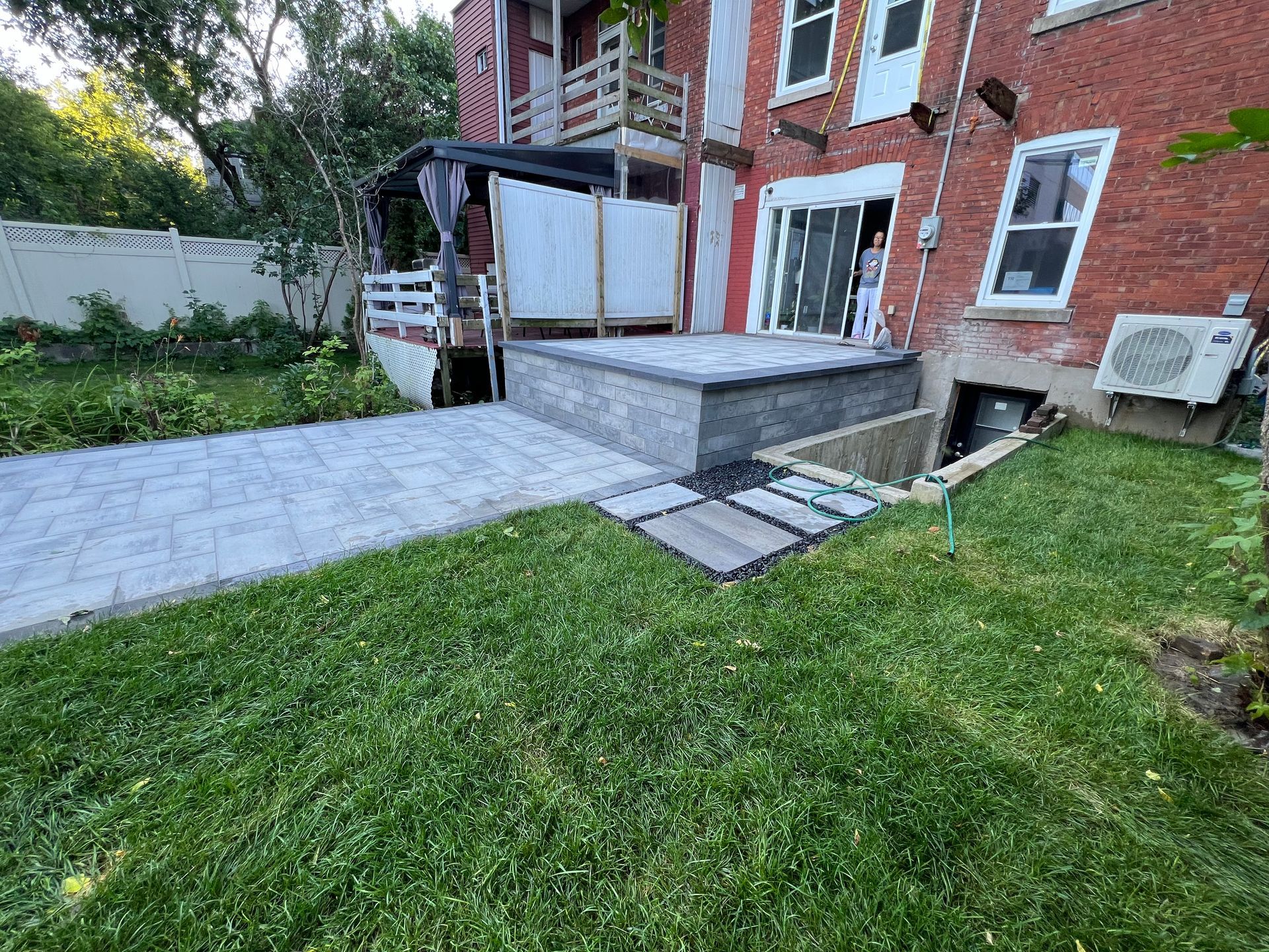 Une maison en brique avec un patio et une passerelle devant elle.