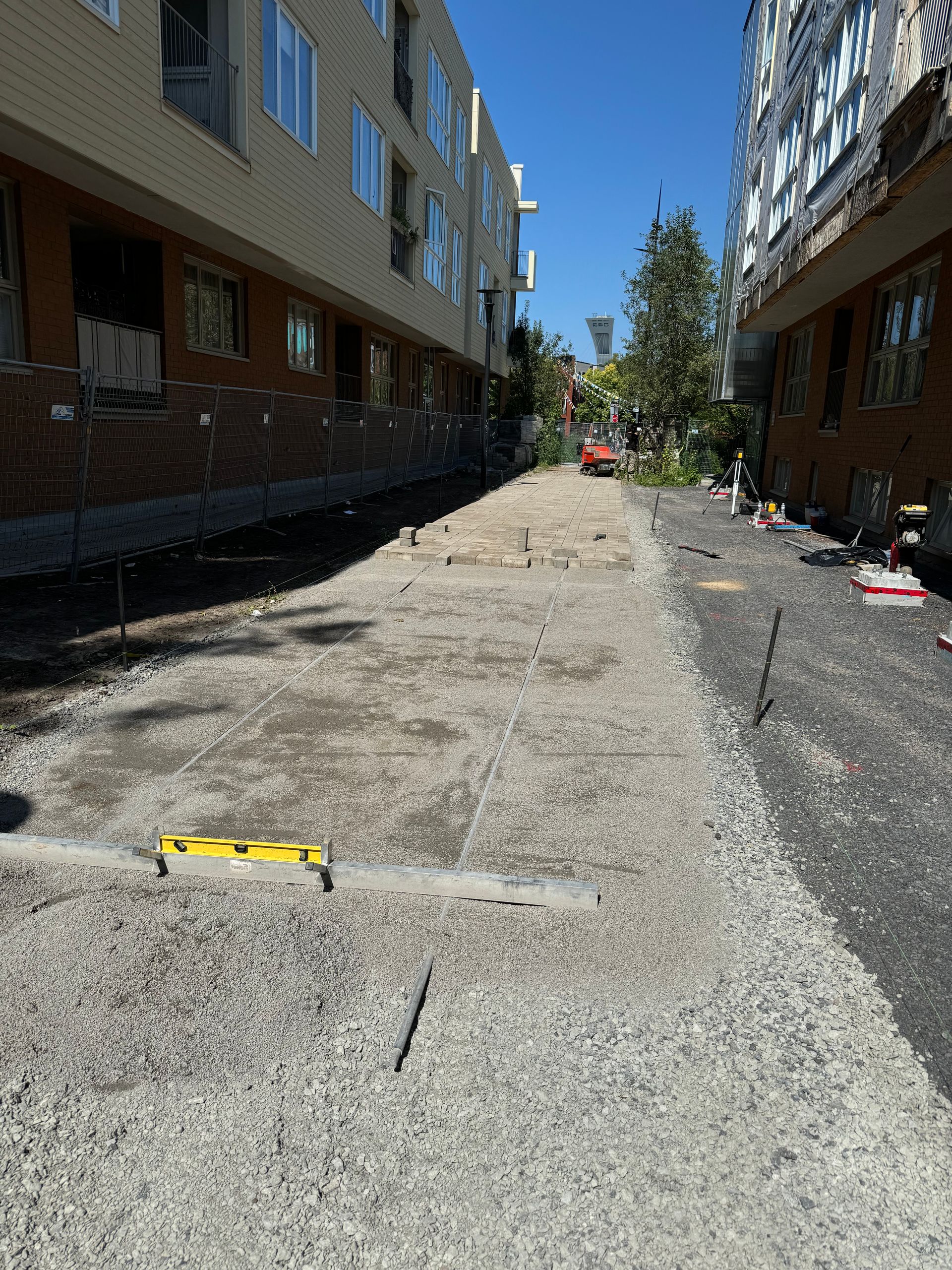 Un bâtiment avec beaucoup de fenêtres se trouve derrière un chemin de gravier