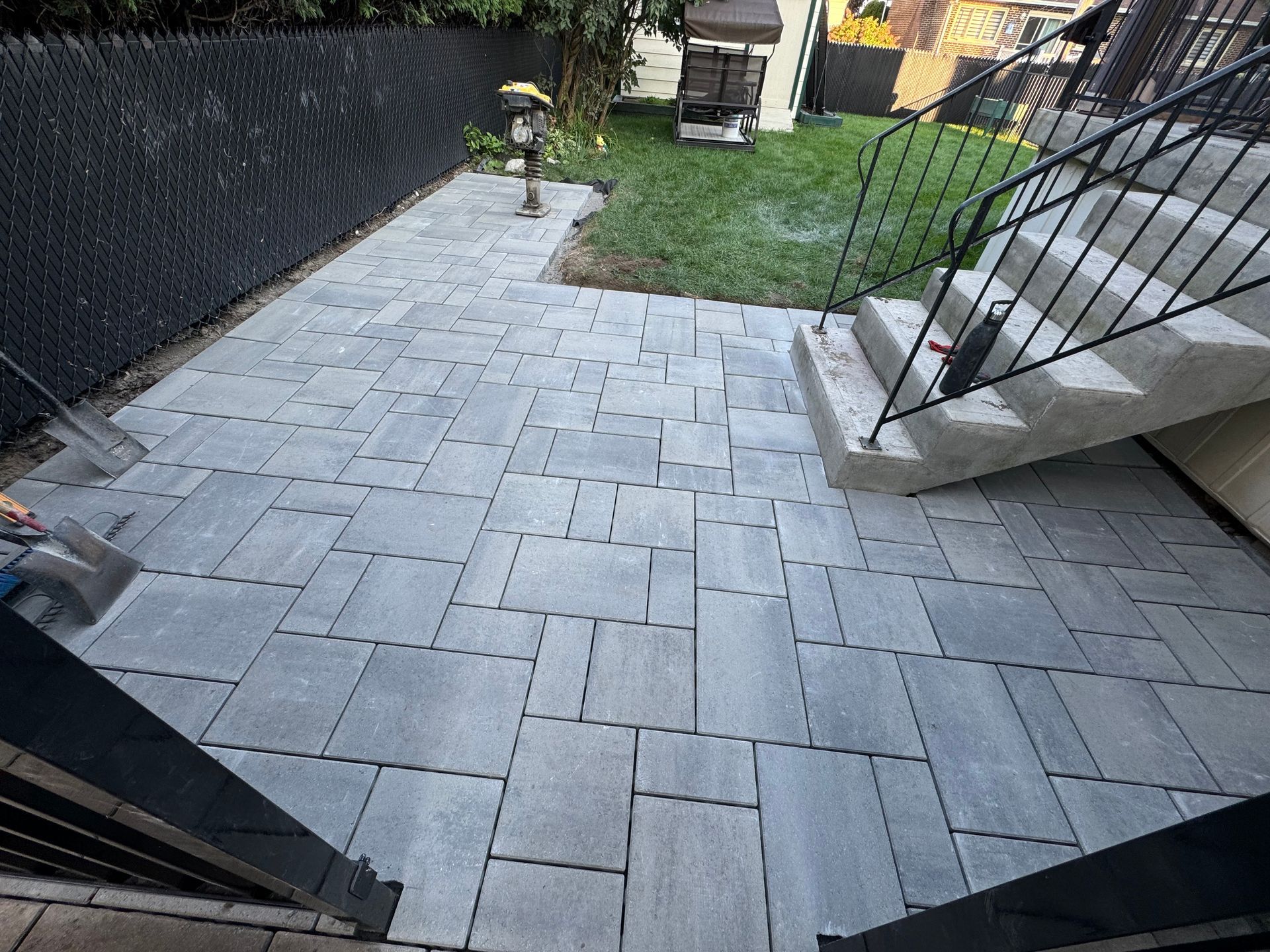 Un patio avec des escaliers et une clôture dans l'arrière-cour d'une maison.