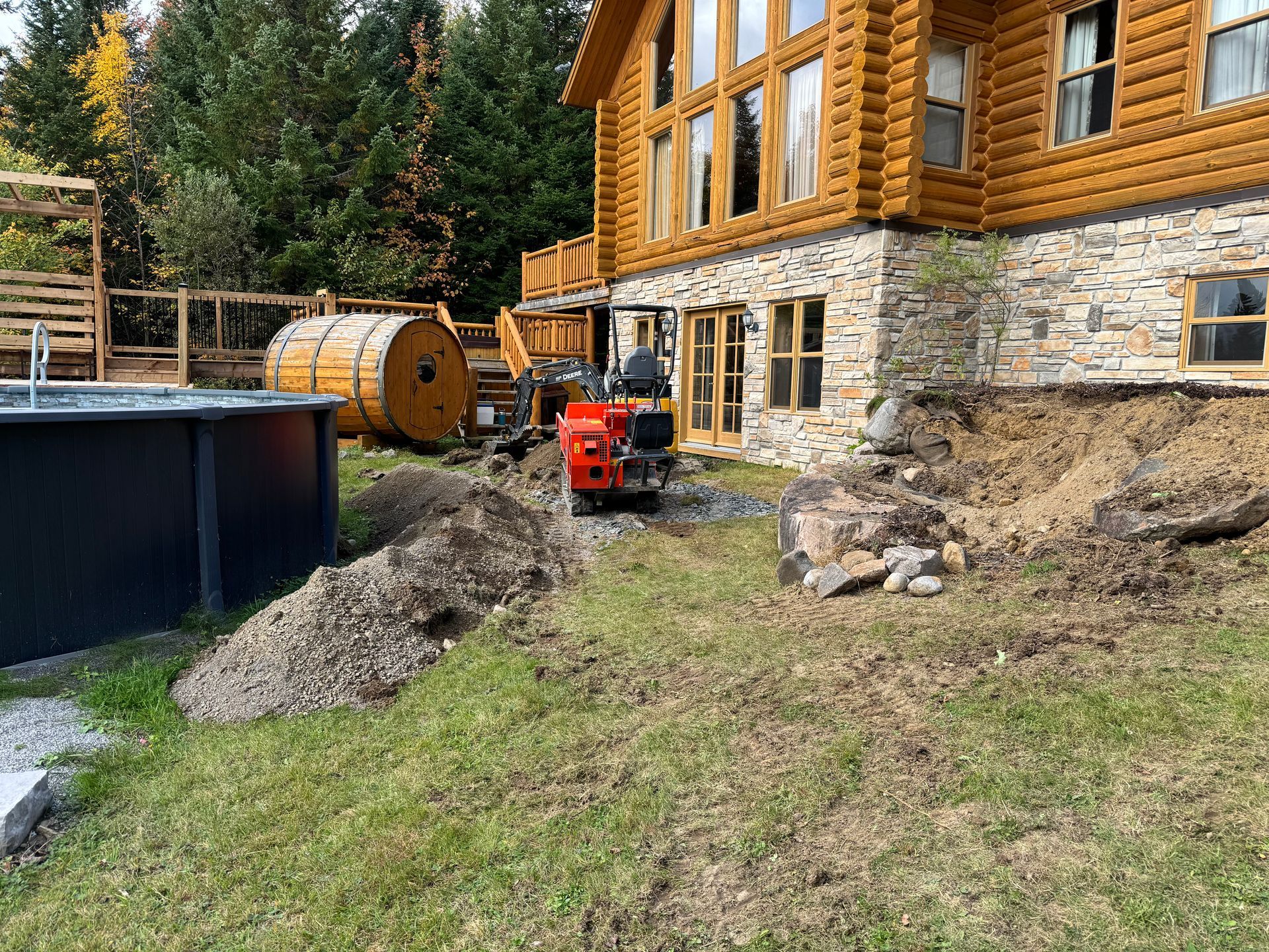 Une grande cabane en rondins avec une piscine devant est en cours de construction.