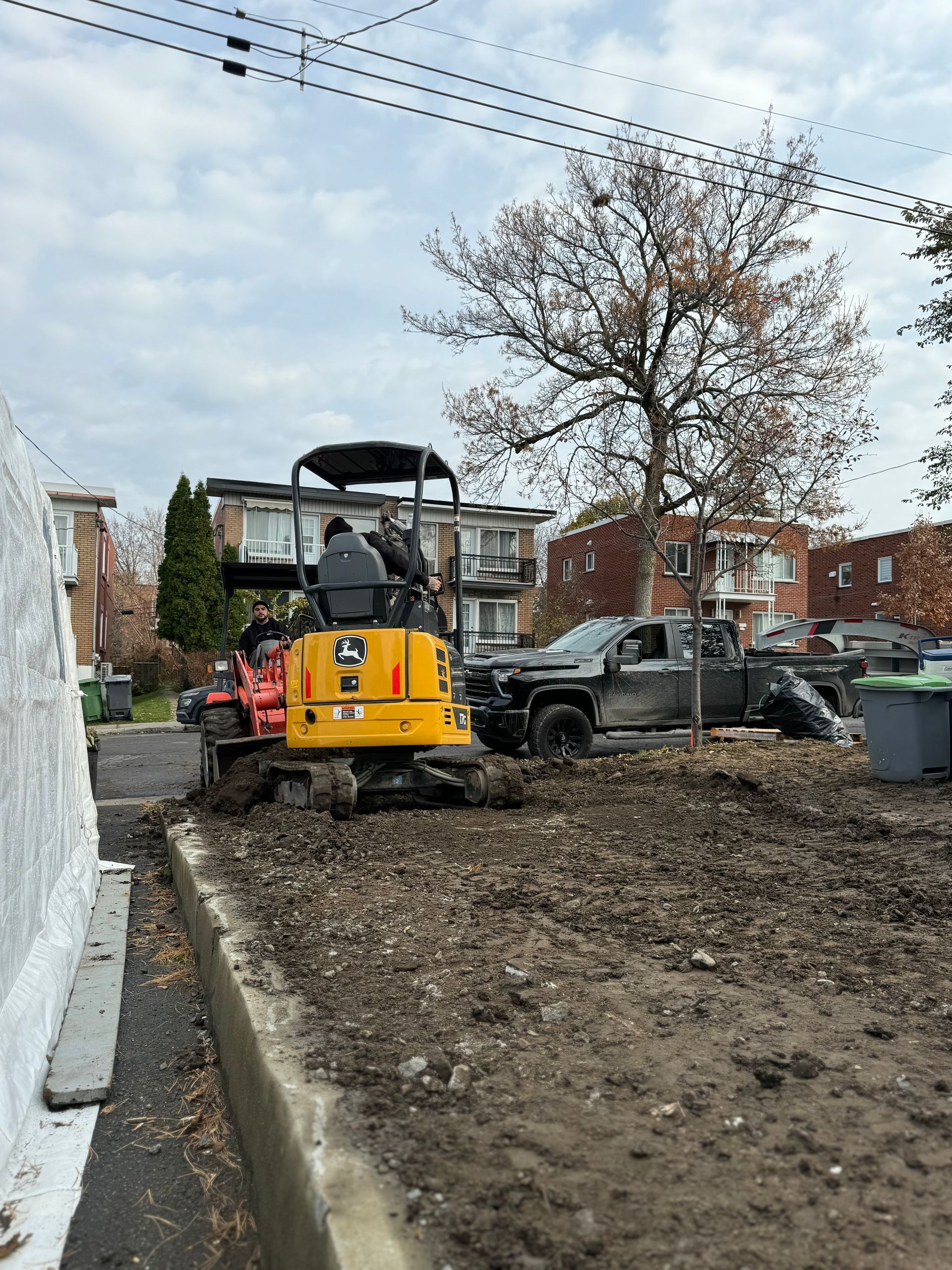 Une petite excavatrice jaune creuse un trou dans le sol.