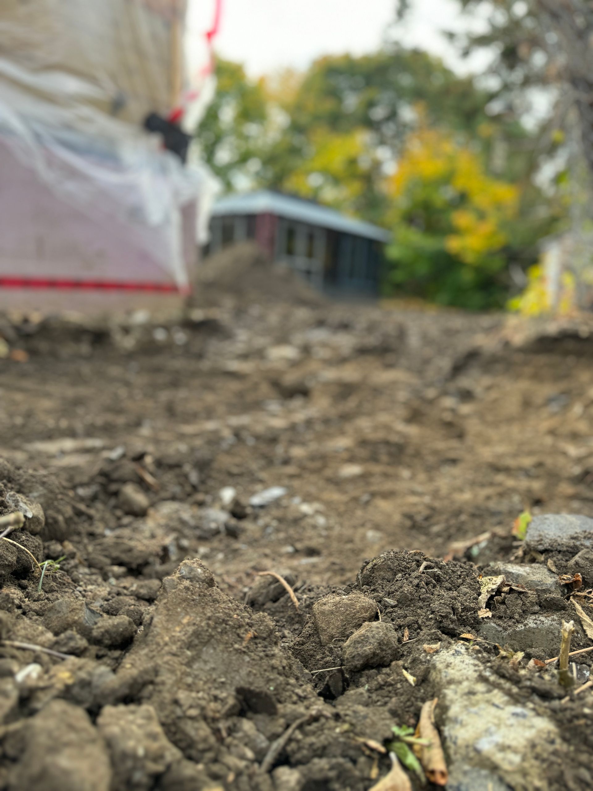 Un gros plan d'un tas de terre avec une maison en arrière-plan.