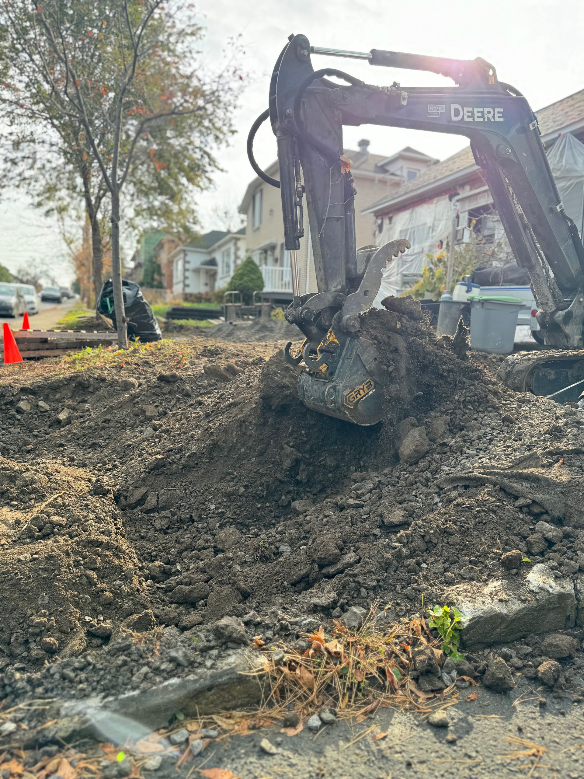 Une grande excavatrice creuse un trou dans le sol.
